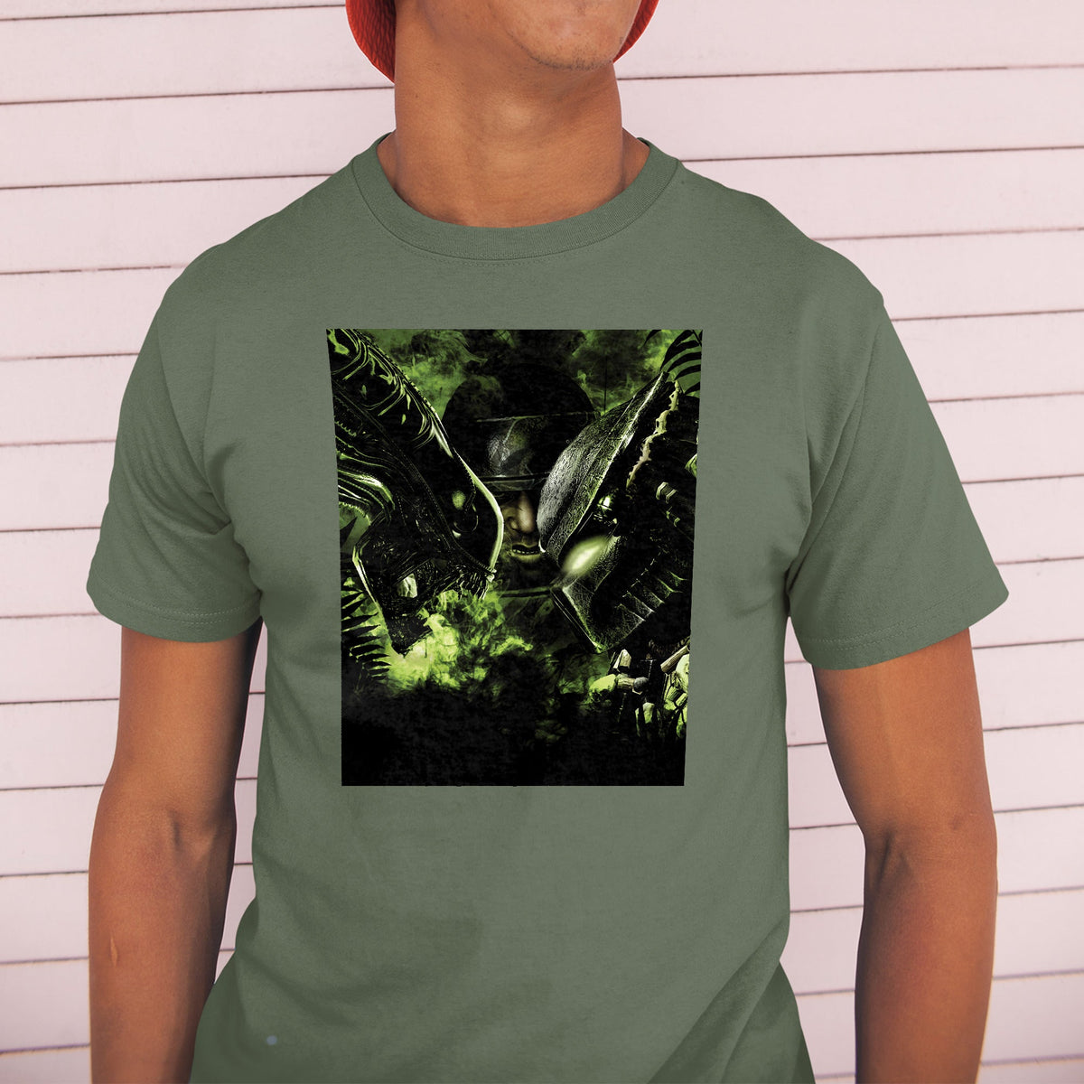 Aliens vs. Predator promotional art tee worn by a model in a cap, green