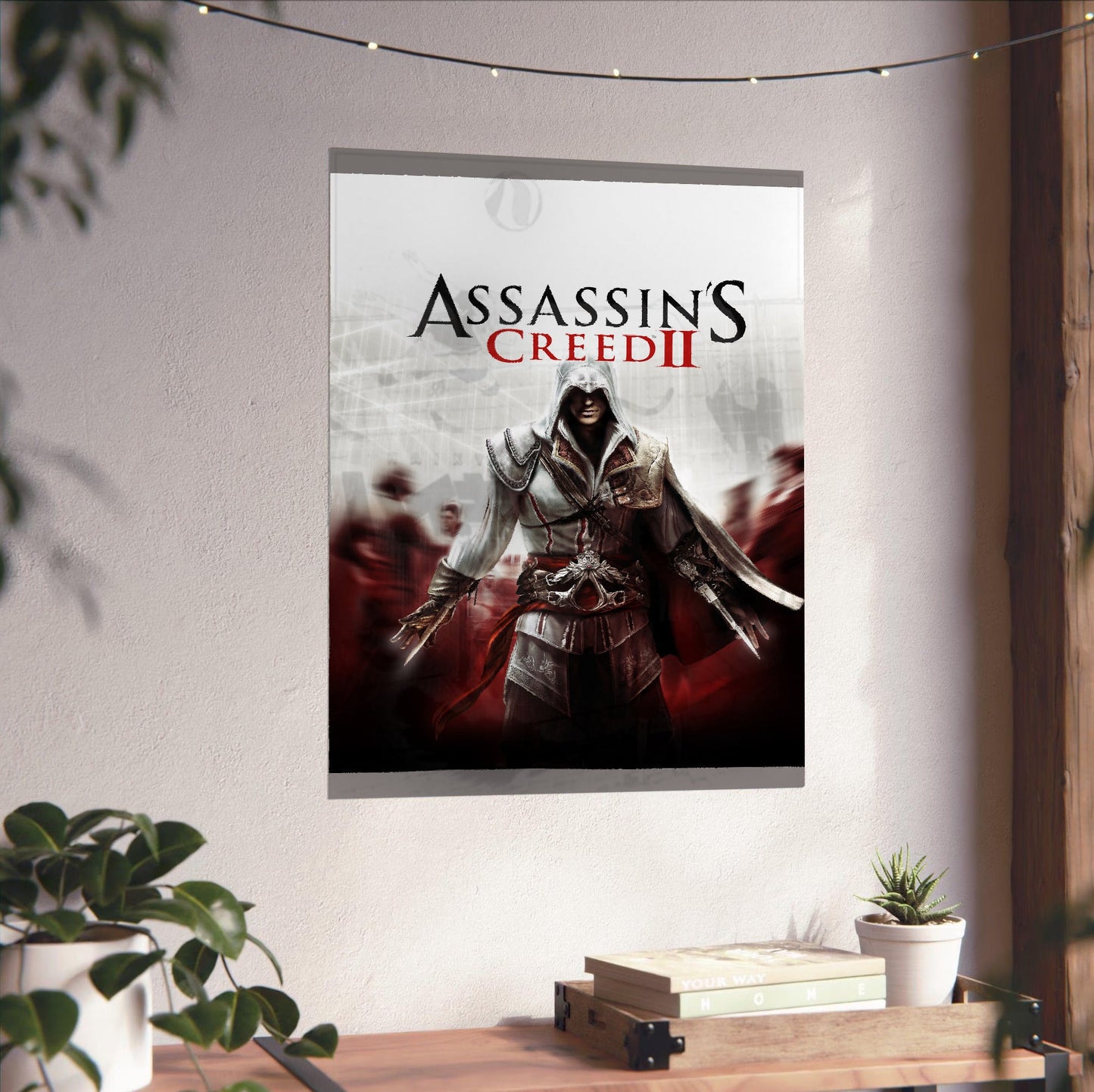 Assassin's Creed II key art unframed on a white wall above a desk