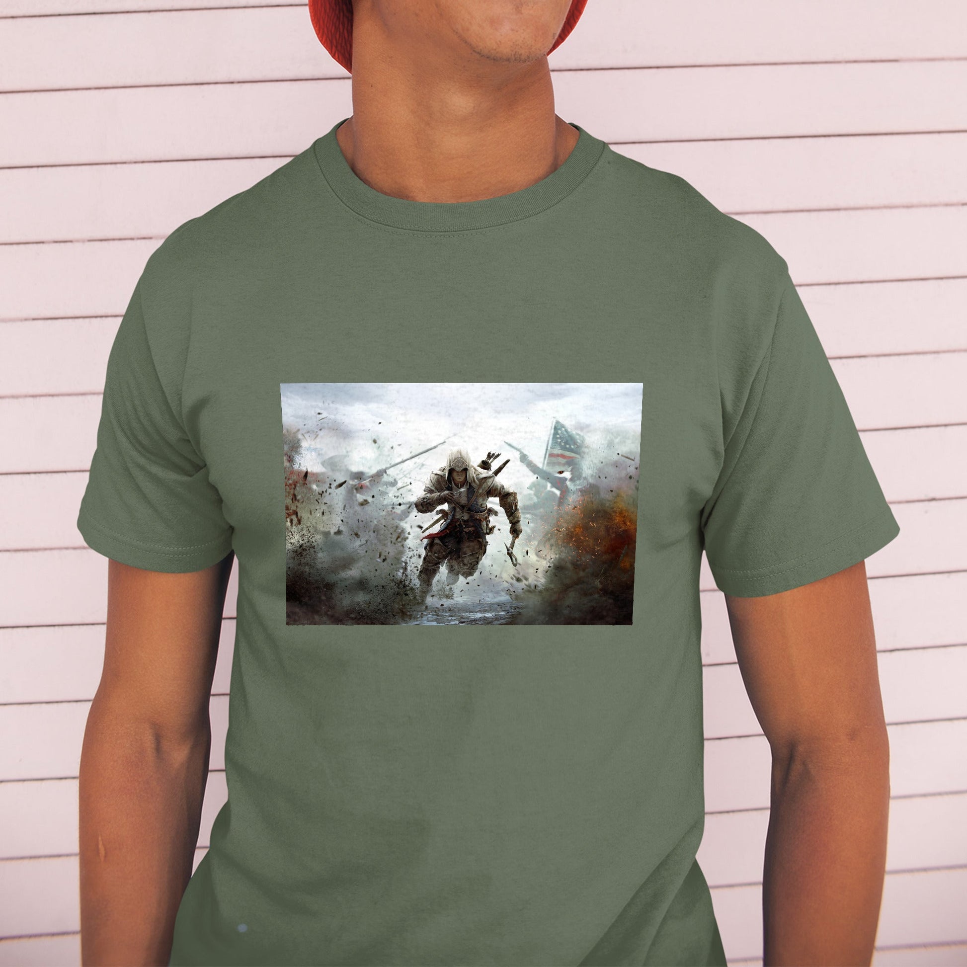 Assassin's Creed III battlefield promo art tee worn by a model in a cap, green