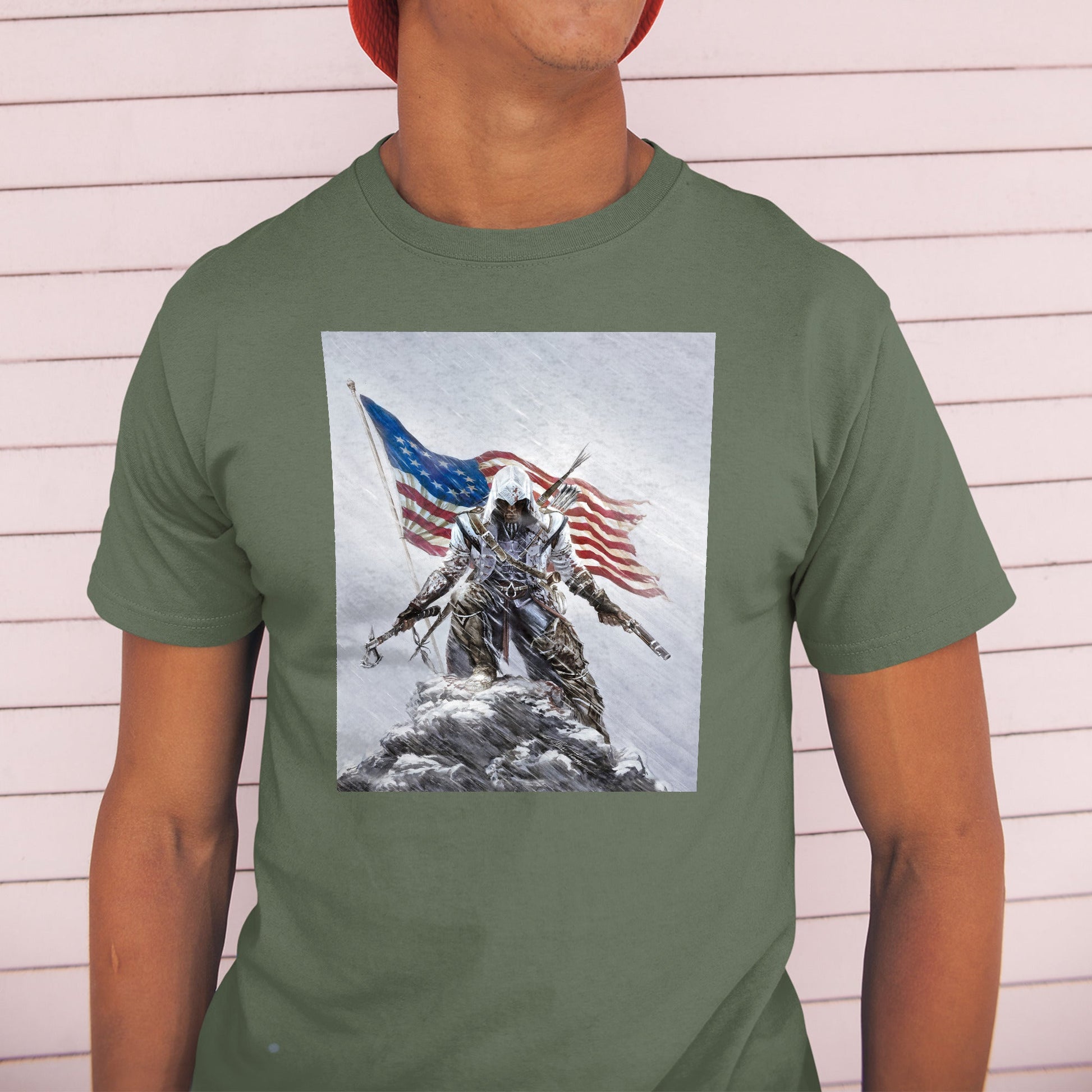 Assassin's Creed III Connor by Alex Ross tee worn by a model in a cap, green