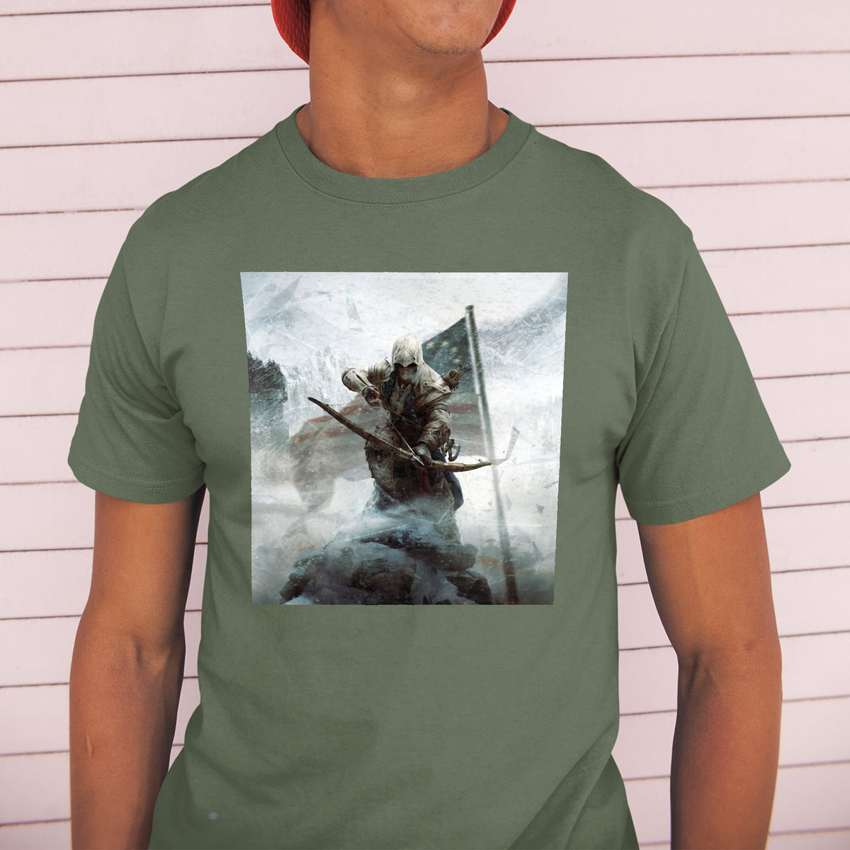 Assassin's Creed III key art tee worn by a model in a cap, green