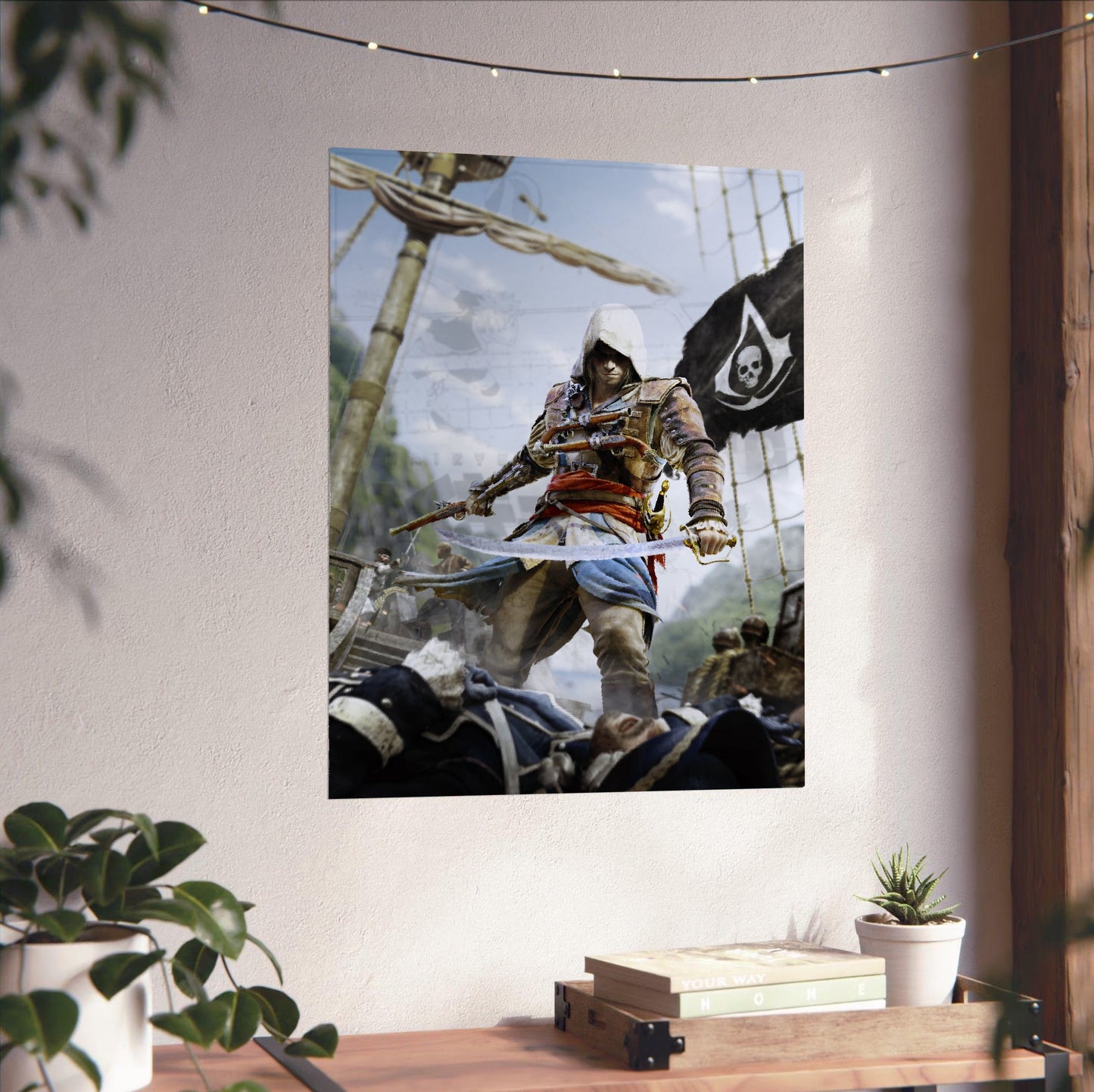 Assassin's Creed IV Black Flag box art unframed on a white wall above a desk