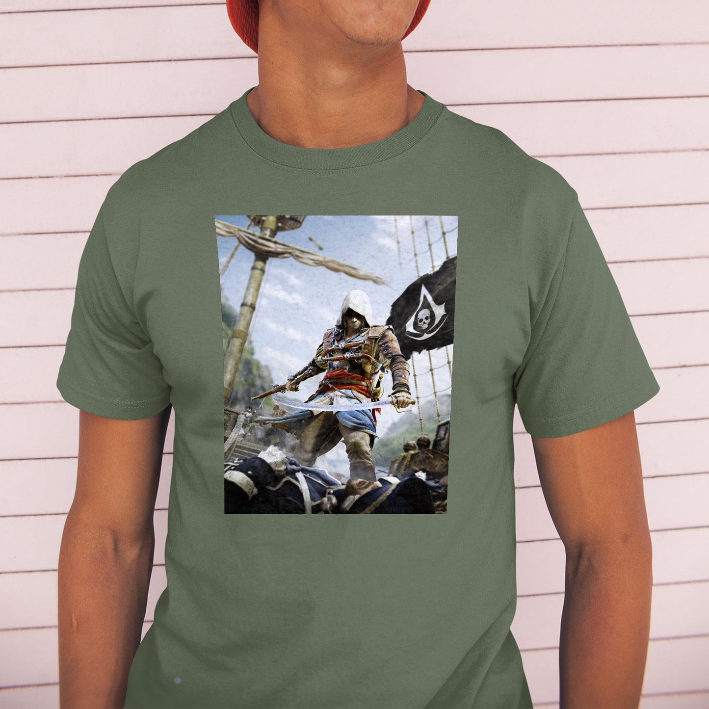 Assassin's Creed IV Black Flag box art tee worn by a model in a cap, green