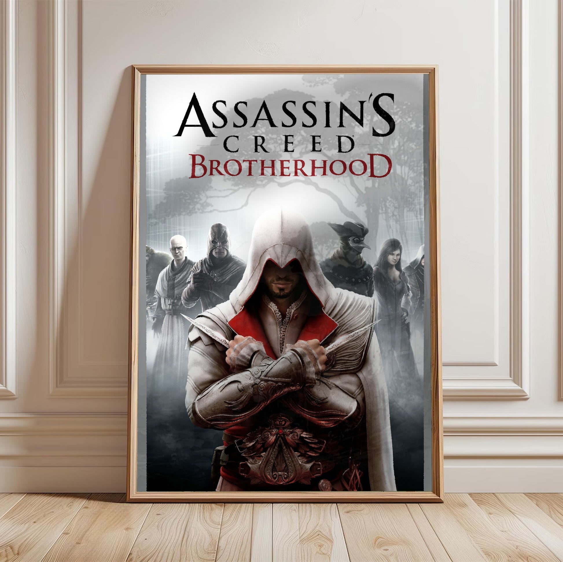Assassin's Creed Brotherhood cover art in a light oak frame leaning against a white wall