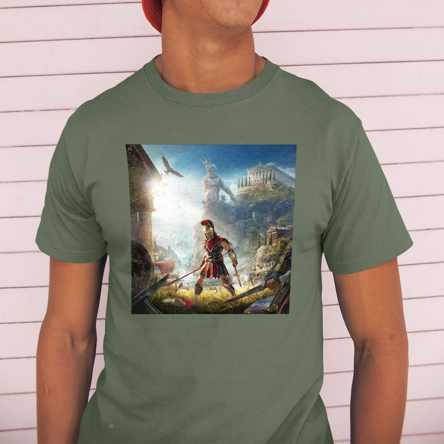 Assassin's Creed Odyssey cover art tee worn by a model in a cap, green