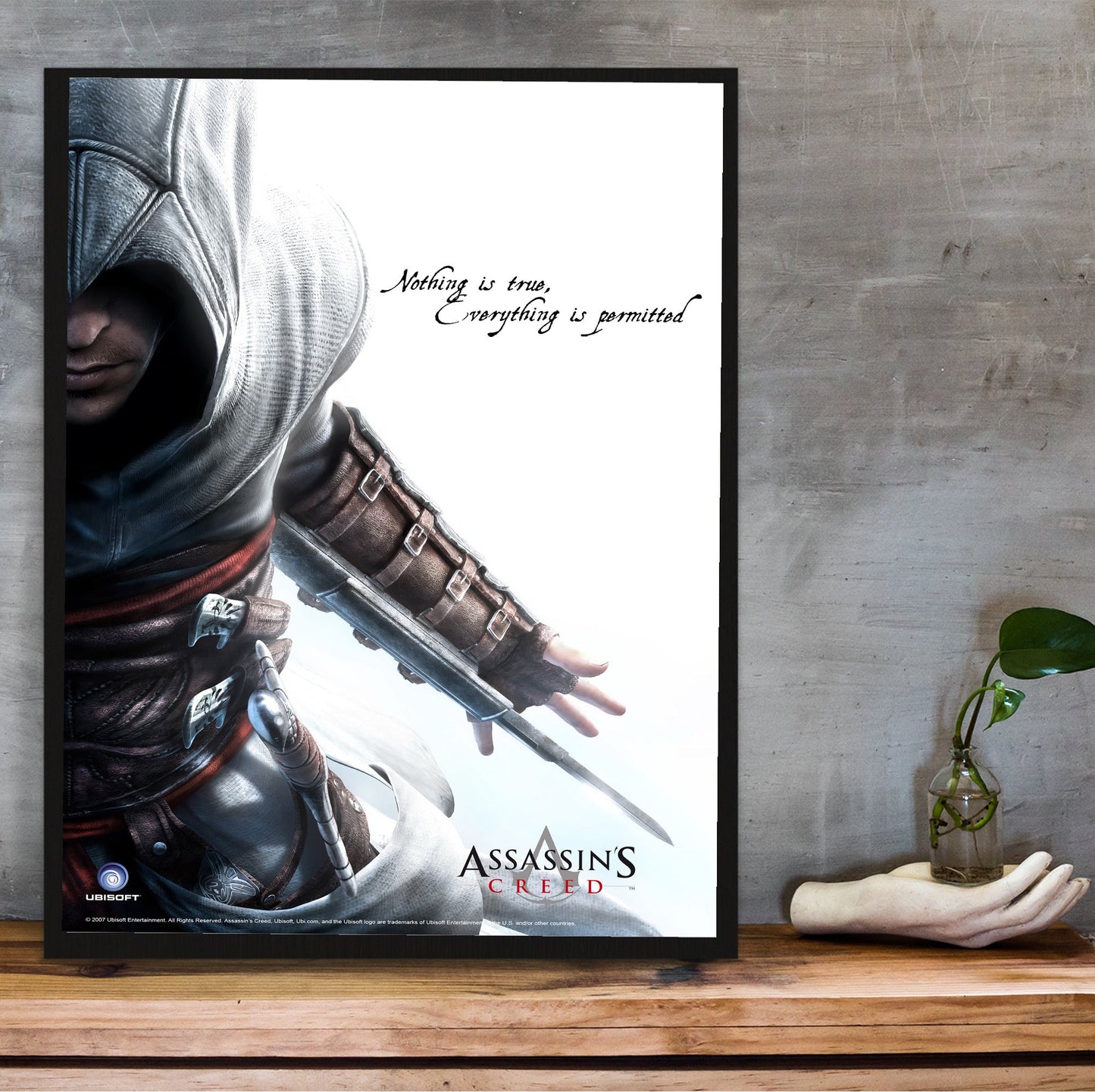 Assassin's Creed Altair promotional art in a black frame on a wooden shelf against concrete