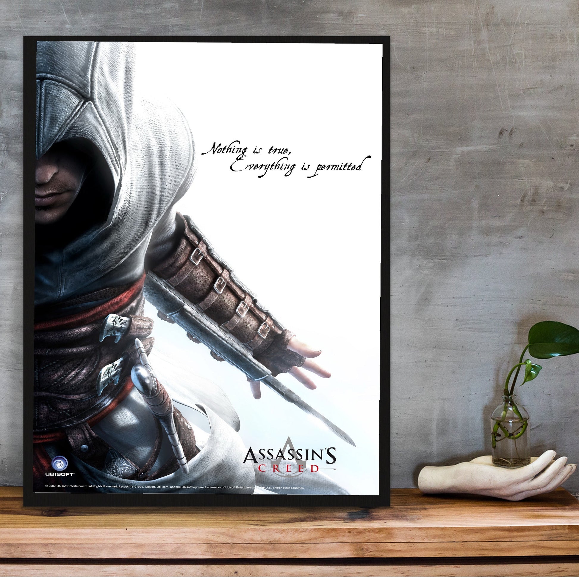 Assassin's Creed Altair promotional art in a black frame on a wooden shelf against concrete