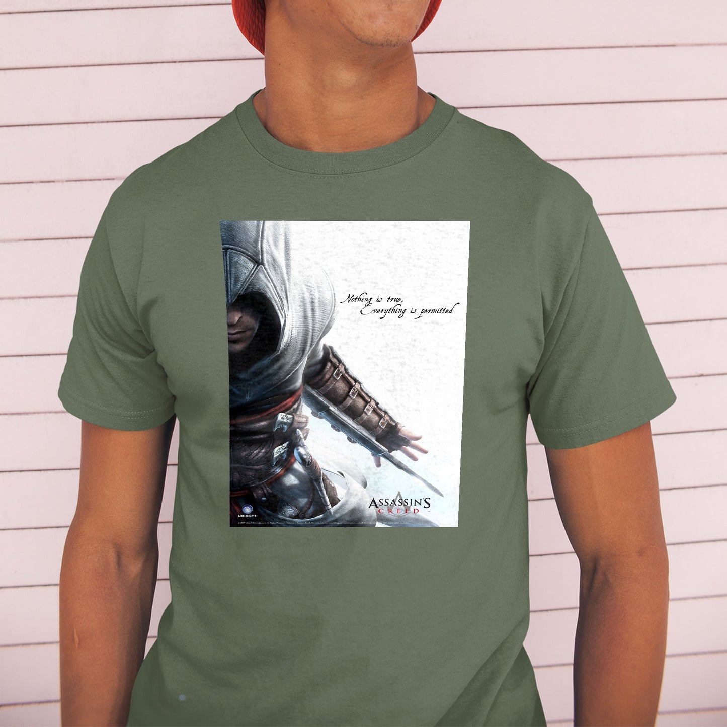 Assassin's Creed Nothing Is True promo art tee worn by a model in a cap, green