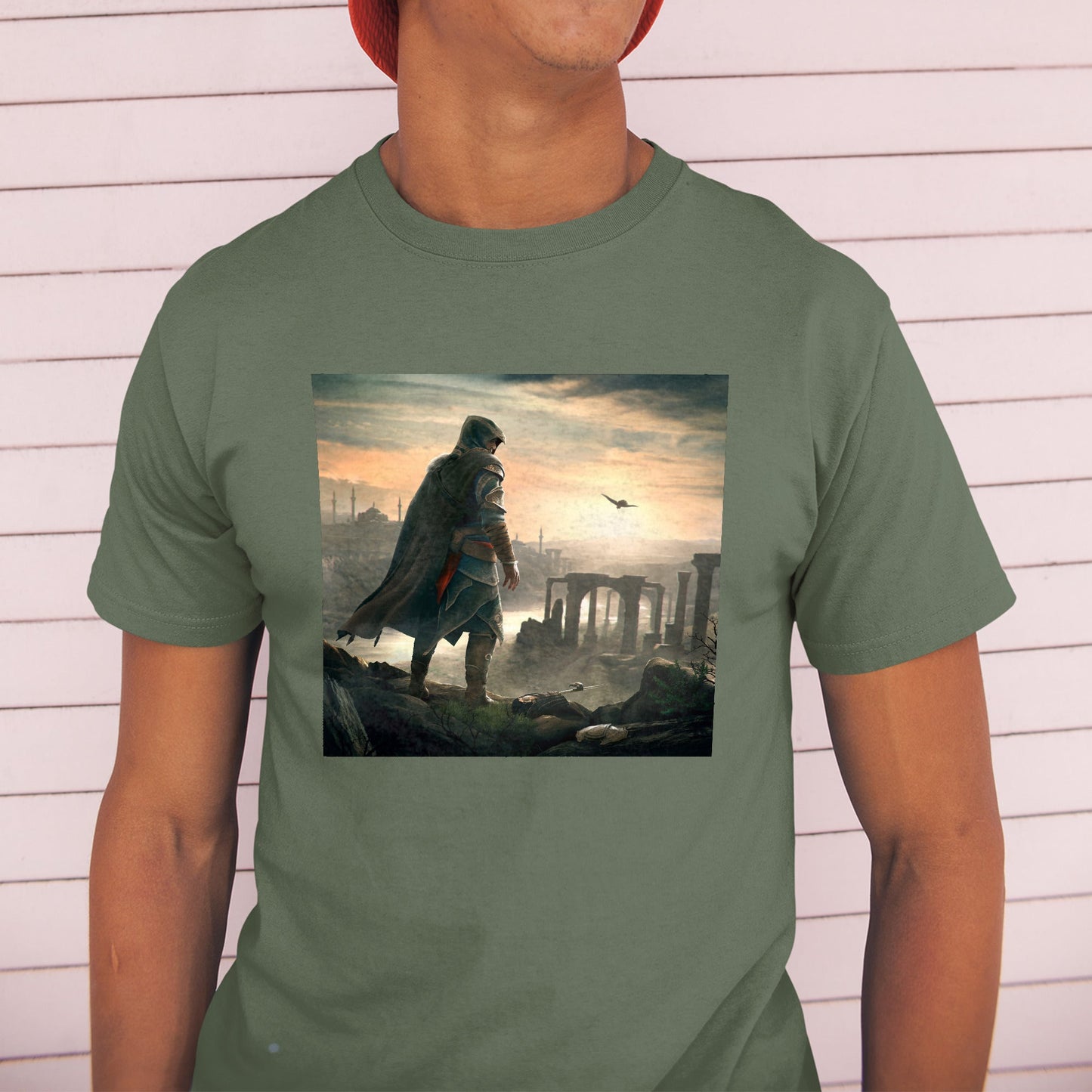 Assassin's Creed Revelations Ezio promo art tee worn by a model in a cap, green