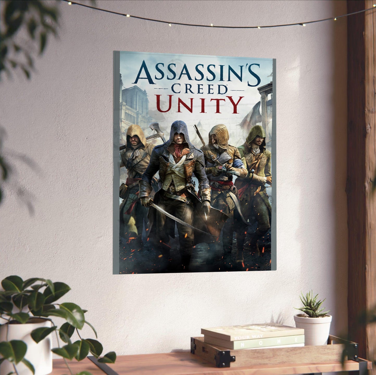 Assassin's Creed Unity cover art unframed on a white wall above a desk