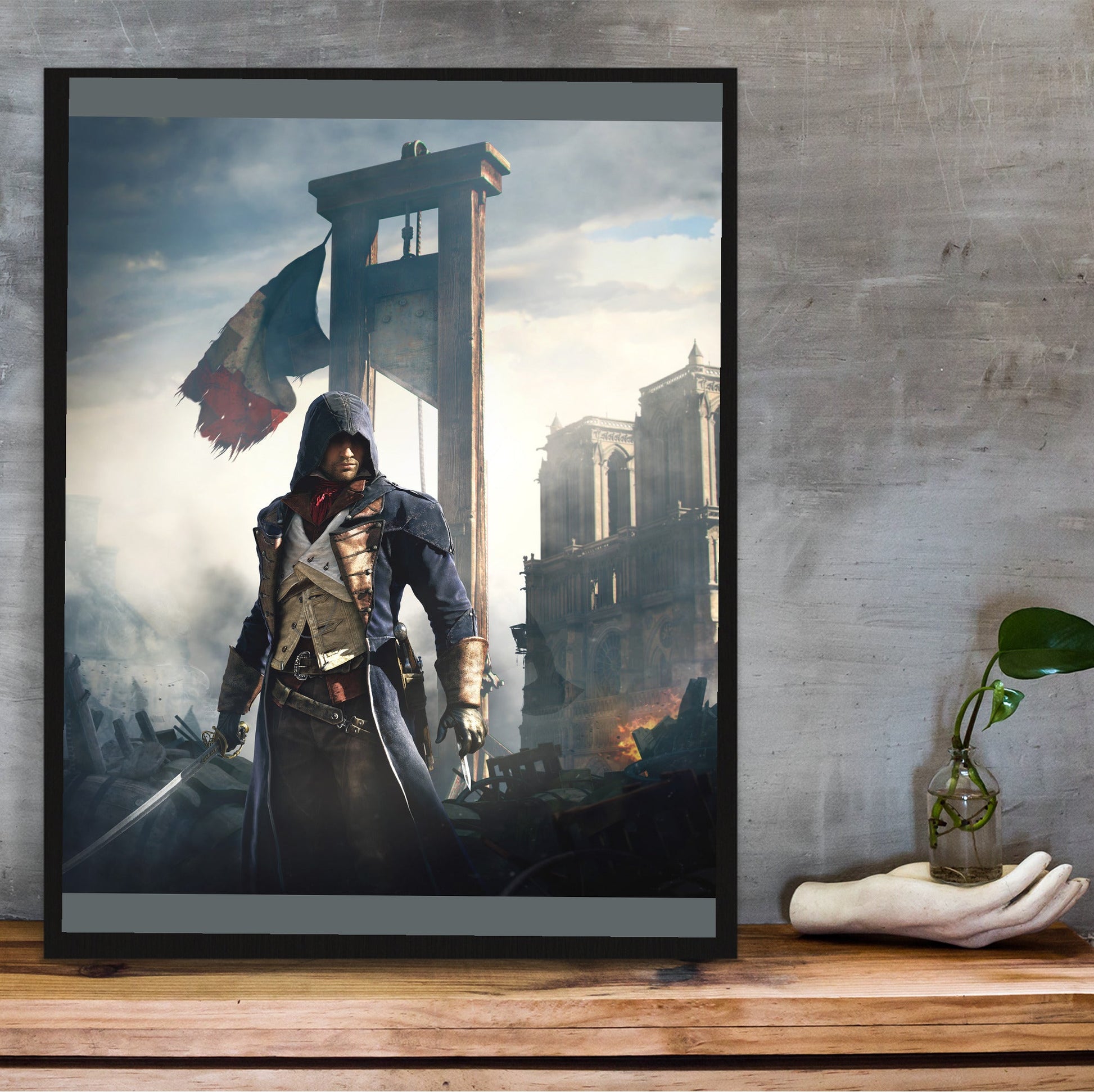 Assassin's Creed Unity alternative key art in a black frame on a wooden shelf against concrete
