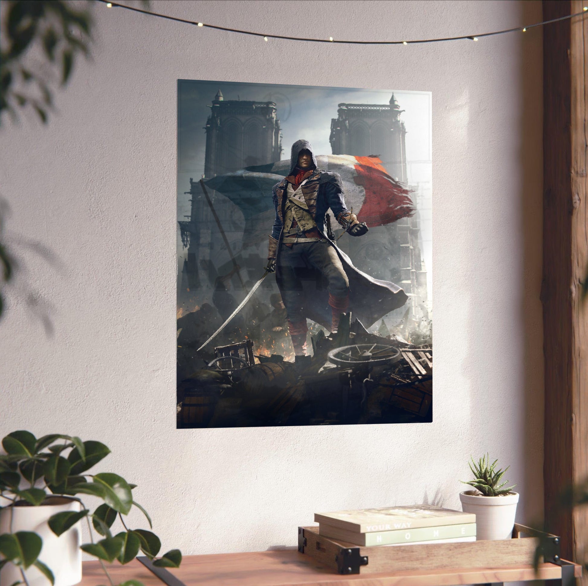 Assassin's Creed Unity key artwork unframed on a white wall above a desk