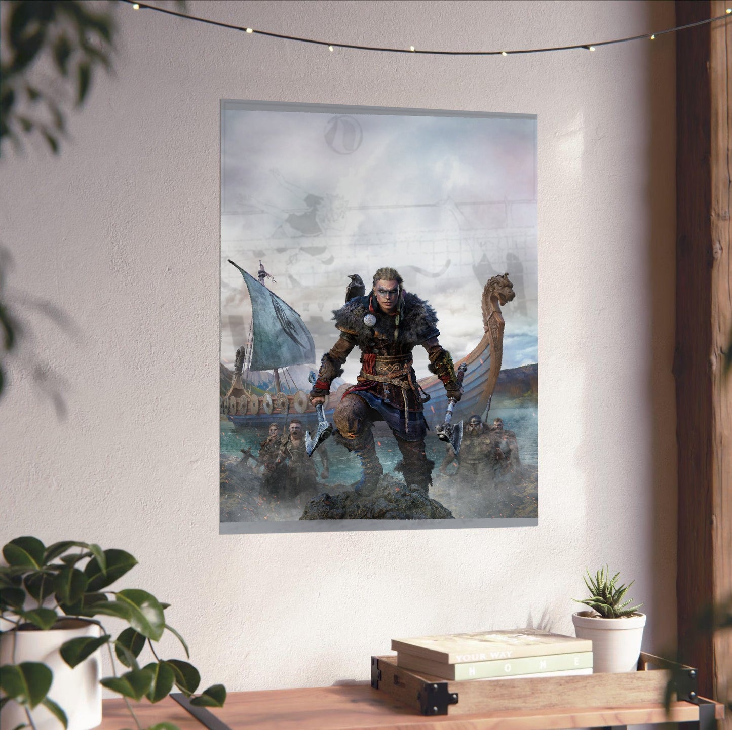 Assassin's Creed Valhalla female Eivor cover art unframed on a white wall above a desk
