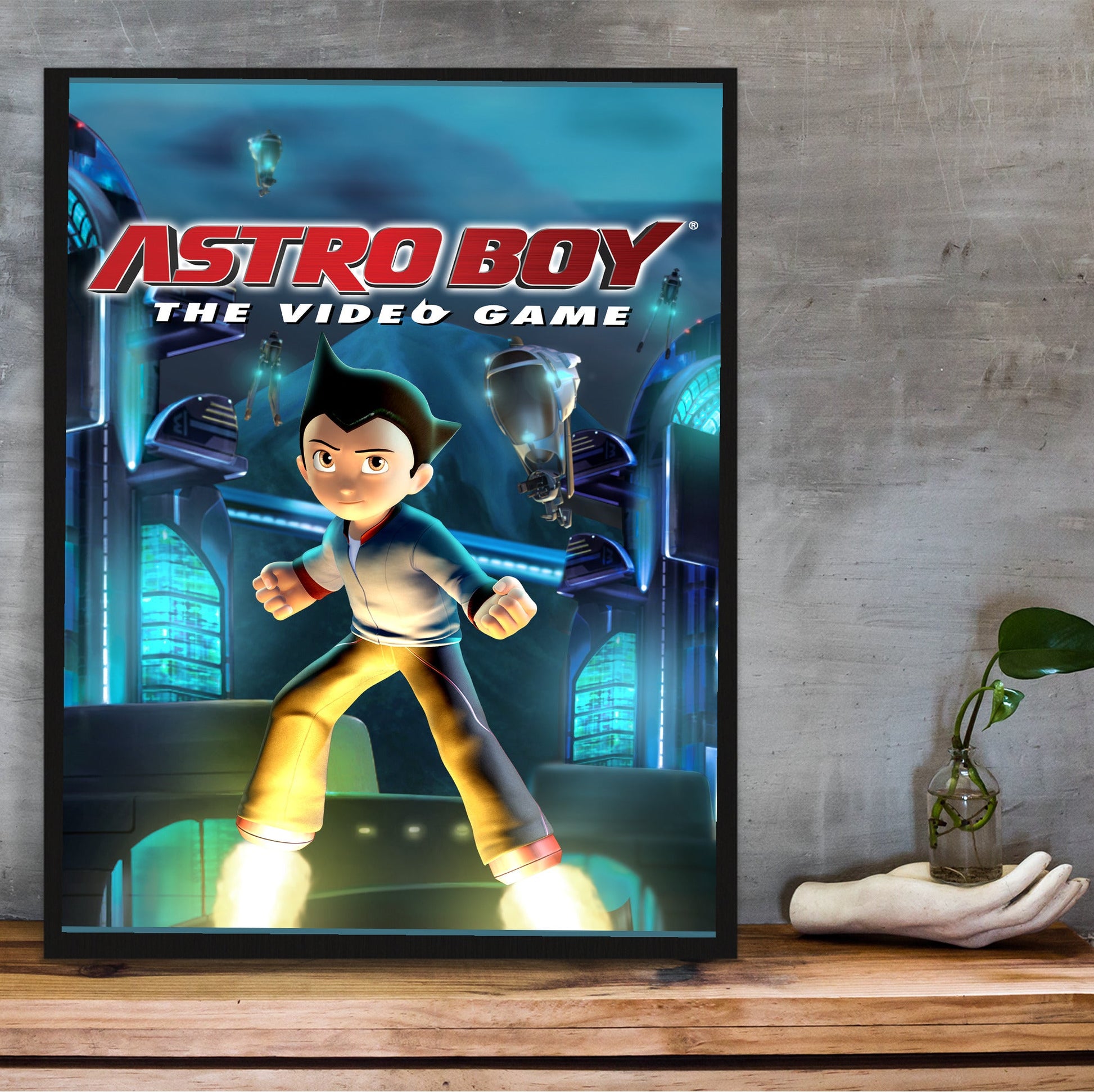 Astro Boy The Video Game key art in a black frame on a wooden shelf against concrete