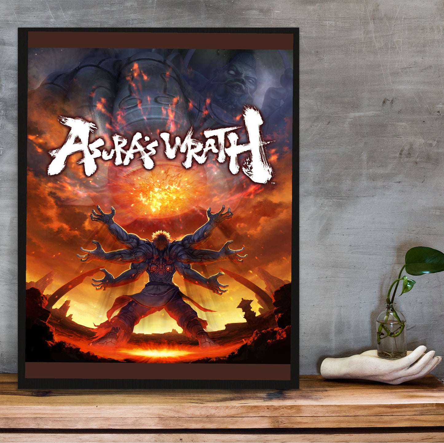 Asura's Wrath E3 artwork with logo in a black frame on a wooden shelf against concrete