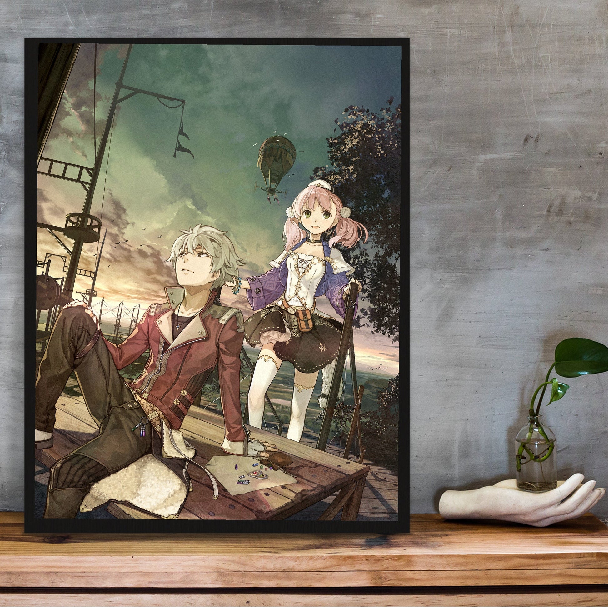 Atelier Escha and Logy Alchemists of the Dusk Sky Main Visual by Hidari in a black frame on a wooden shelf against concrete