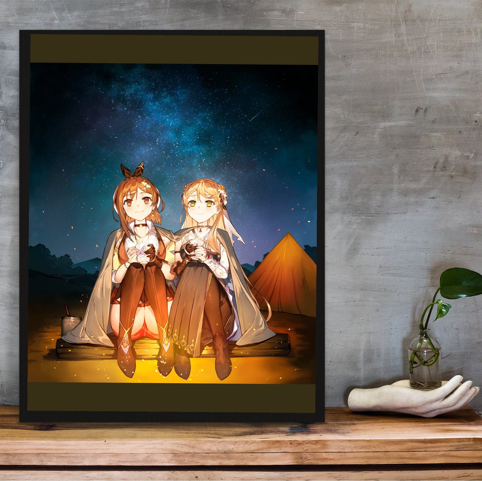 Atelier Ryza 3 Ryza and Klaudia Illustration in a black frame on a wooden shelf against concrete