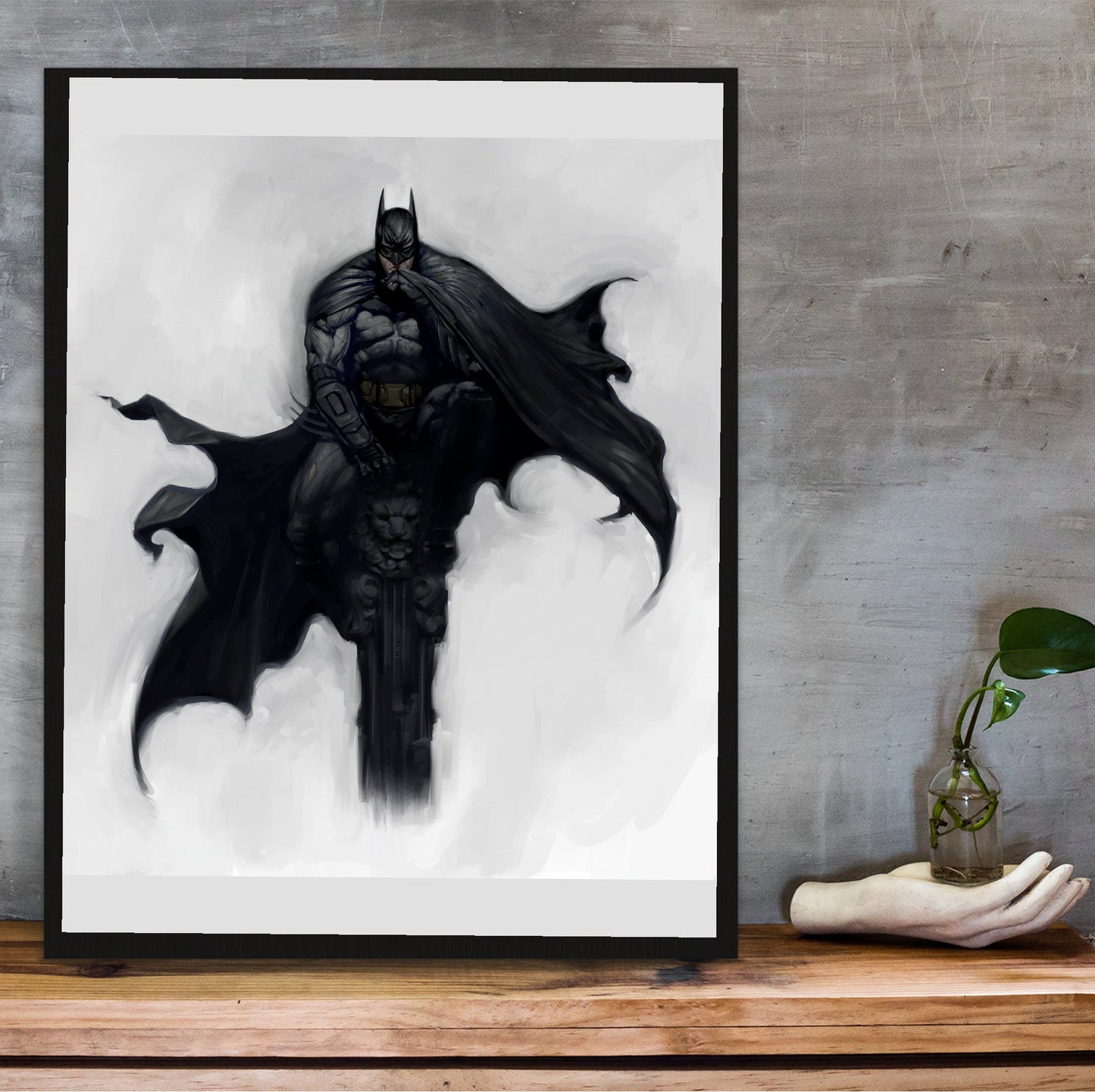 Batman Arkham City Batman concept art by Kan Muftic poster in a black frame on a wooden shelf against concrete