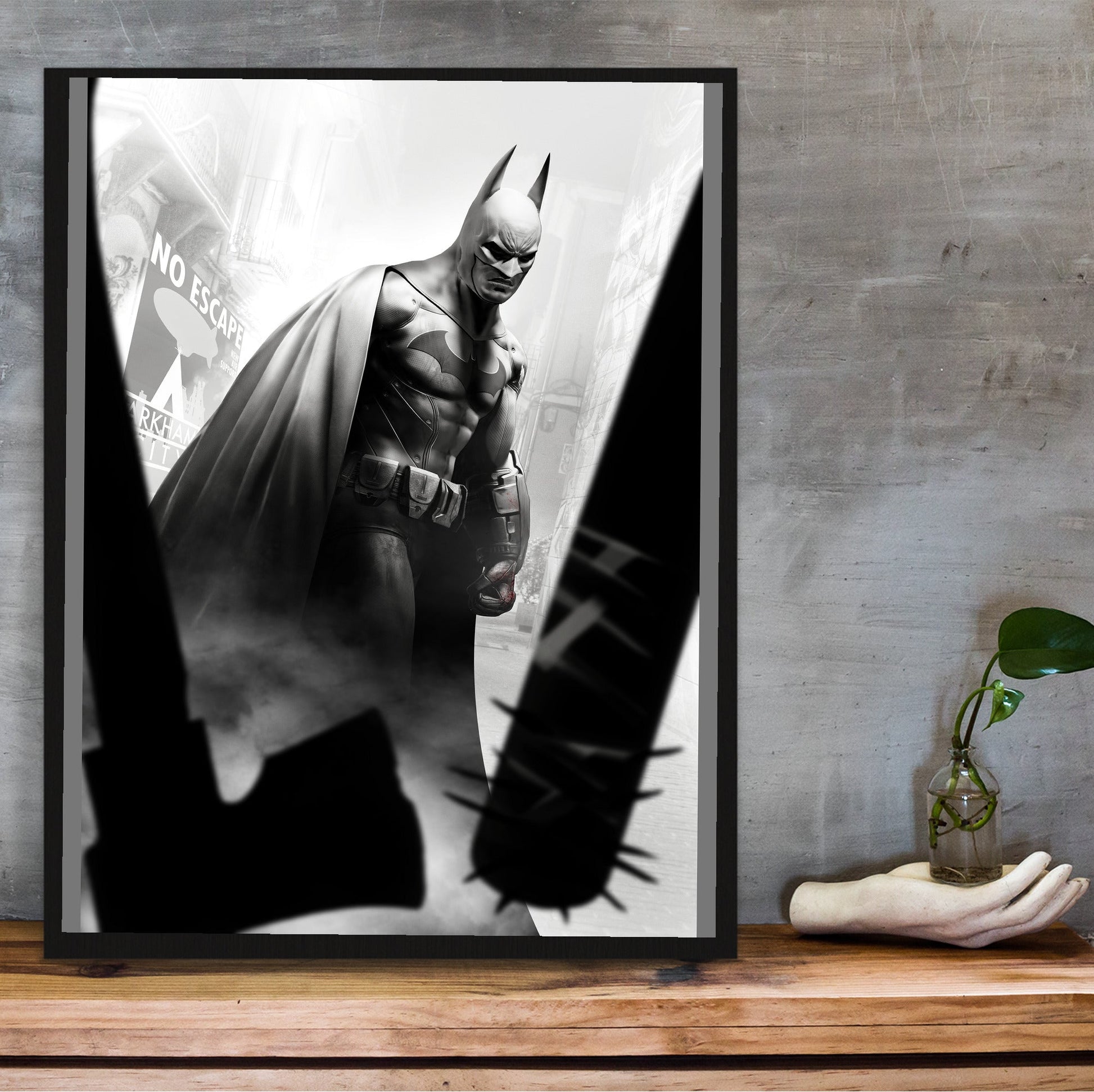 Batman Arkham City Batman vs thugs art poster in a black frame on a wooden shelf against concrete