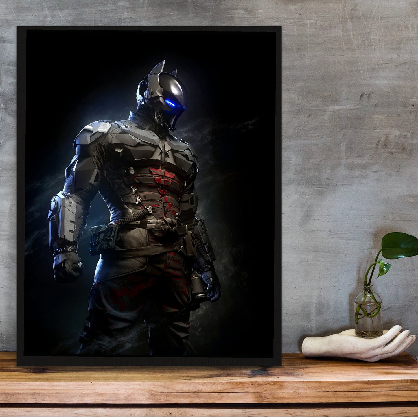 Batman Arkham Knight armoured Arkham Knight character art poster in a black frame on a wooden shelf against concrete