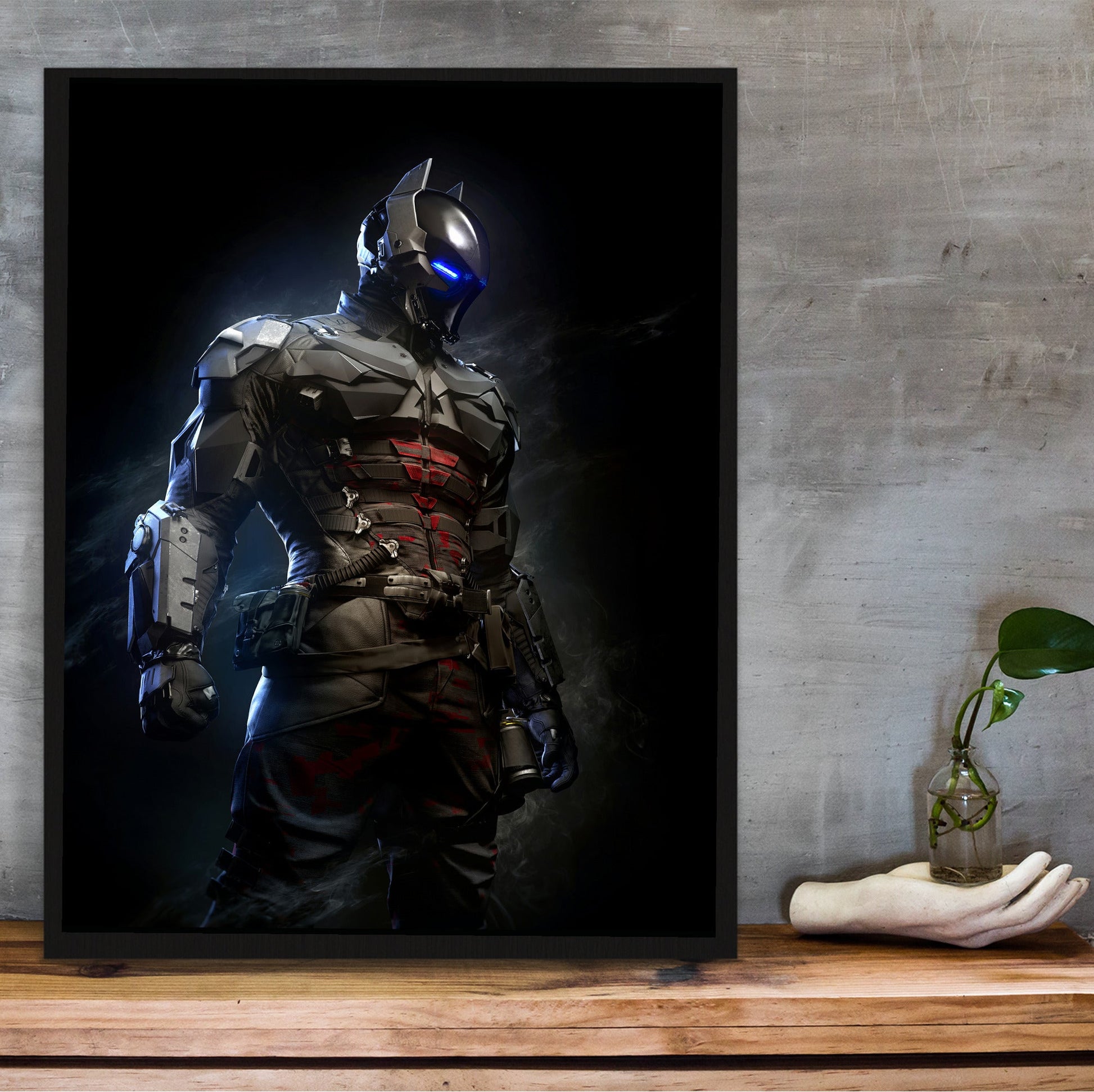 Batman Arkham Knight armoured Arkham Knight character art poster in a black frame on a wooden shelf against concrete