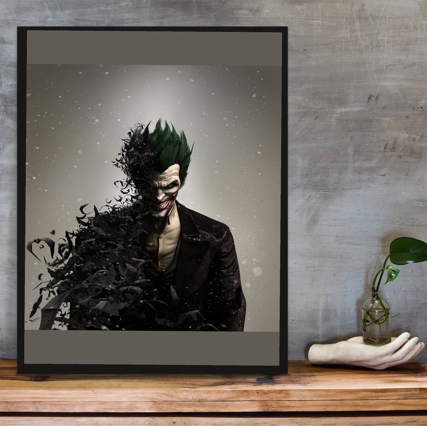 Batman Arkham Origins Joker promo art poster in a black frame on a wooden shelf against concrete
