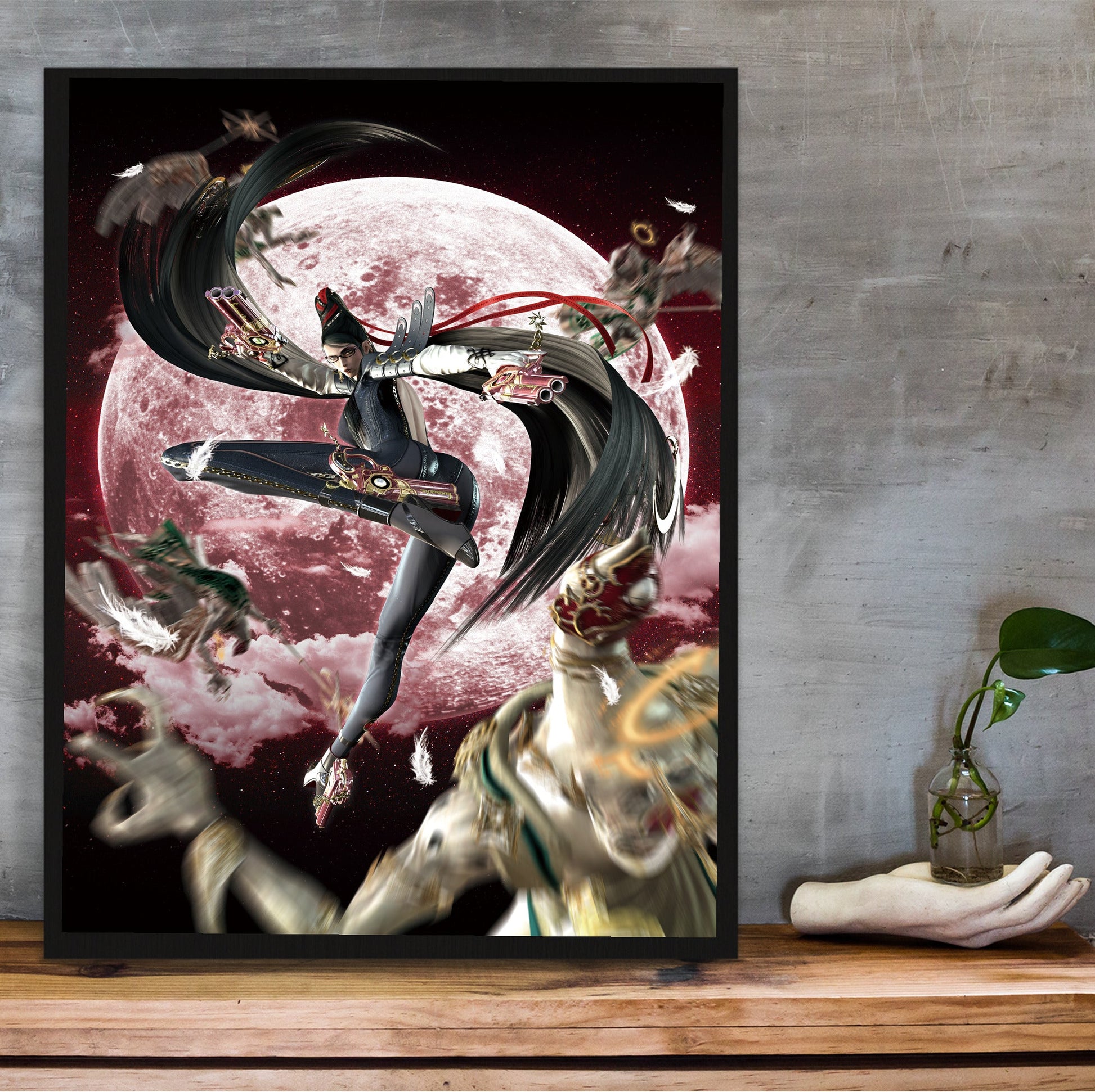 Bayonetta crimson moon key artwork poster in a black frame on a wooden shelf against concrete