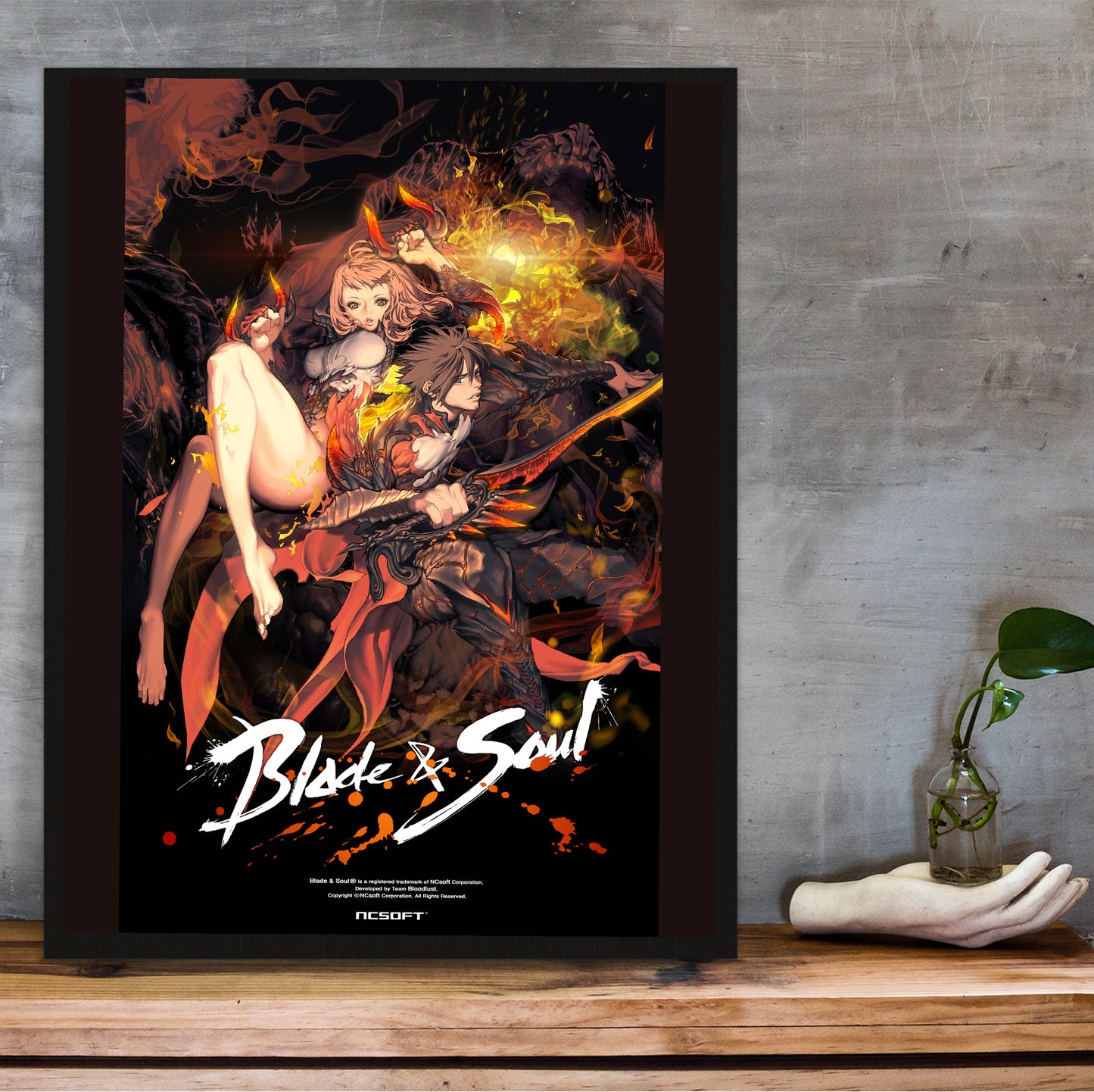 Blade & Soul flame promo poster hung above a desk