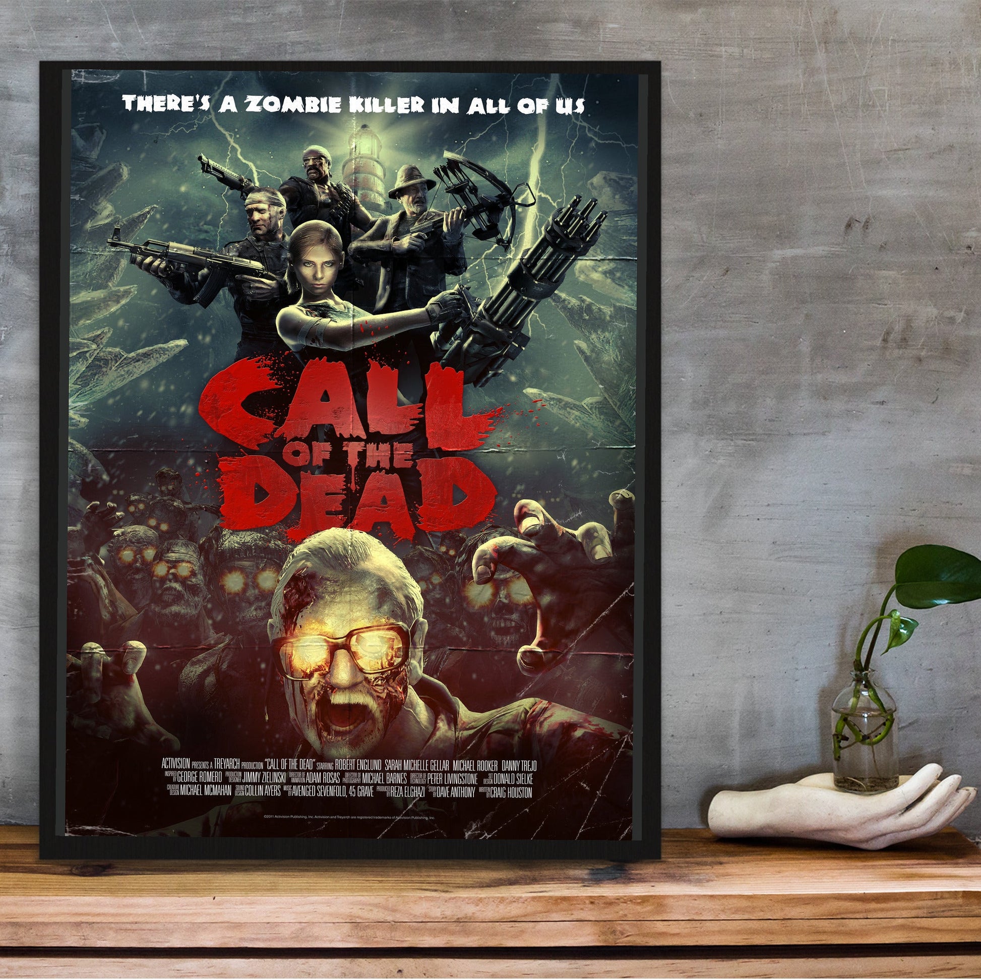 Call of Duty Black Ops Call of the Dead zombies art in a black frame on a wooden shelf against concrete