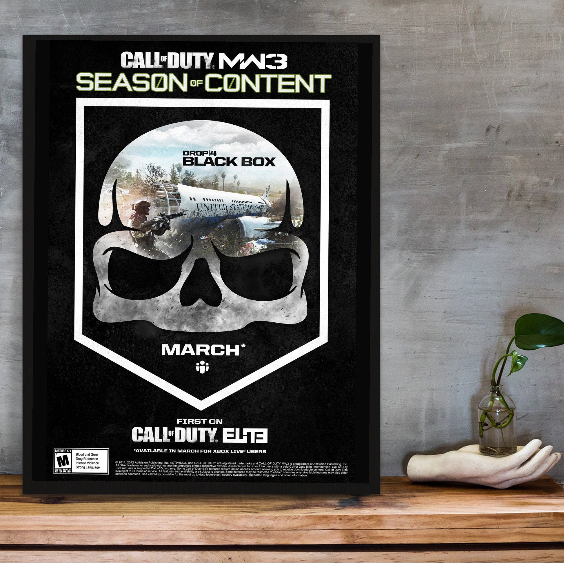 Call of Duty Modern Warfare 3 Black Box season art in a black frame on a wooden shelf against concrete