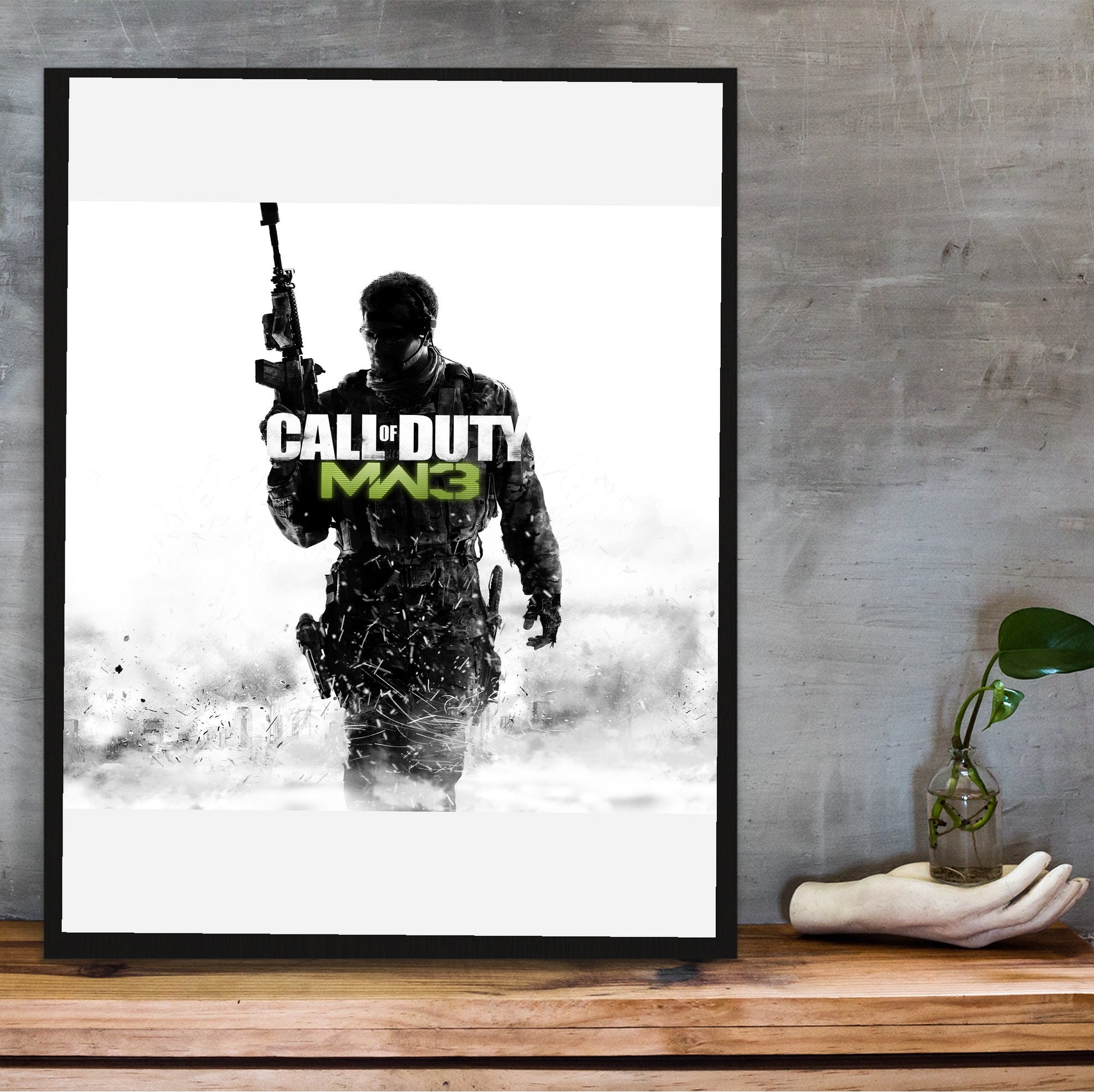 Call of Duty Modern Warfare 3 cover art with logo in a black frame on a wooden shelf against concrete