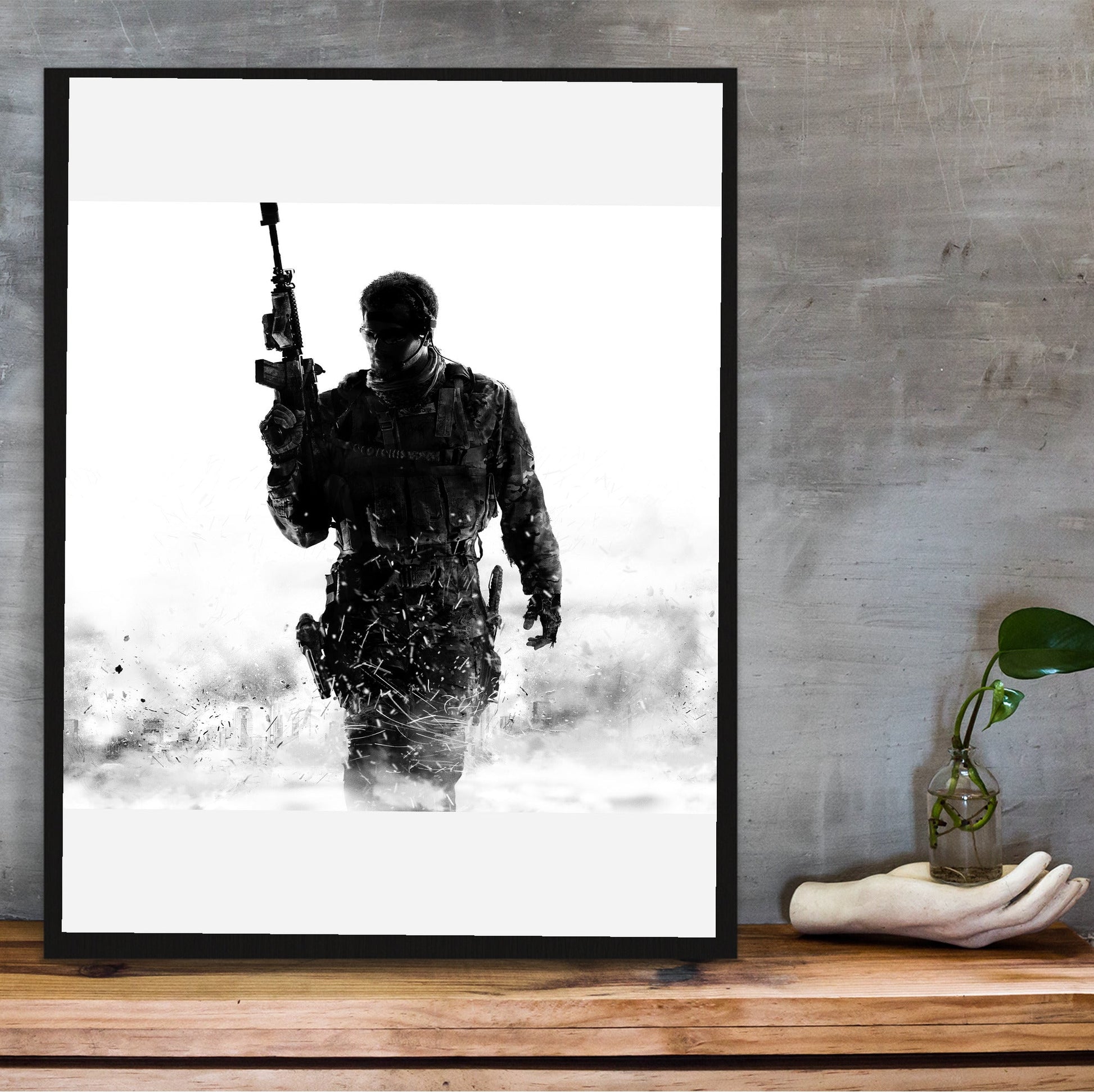 Call of Duty Modern Warfare 3 cover art in a black frame on a wooden shelf against concrete