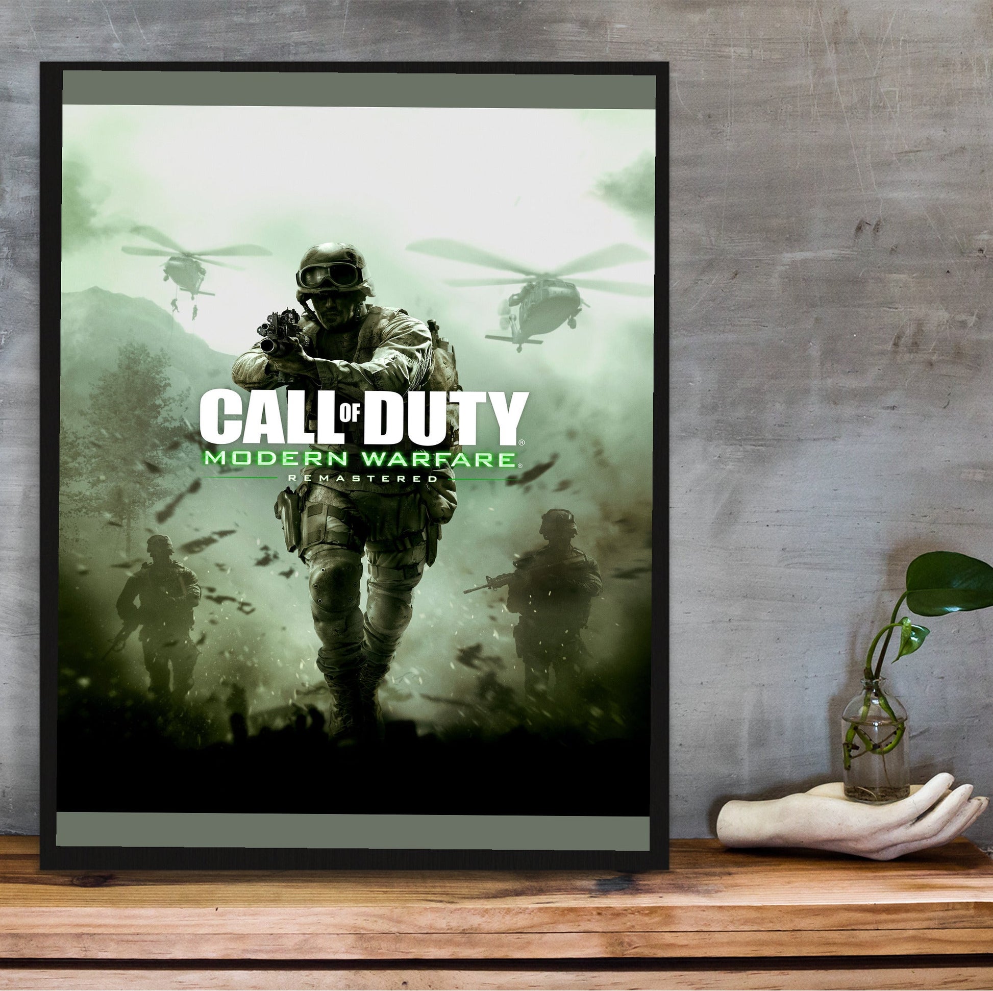 Call of Duty Modern Warfare Remastered key art in a black frame on a wooden shelf against concrete