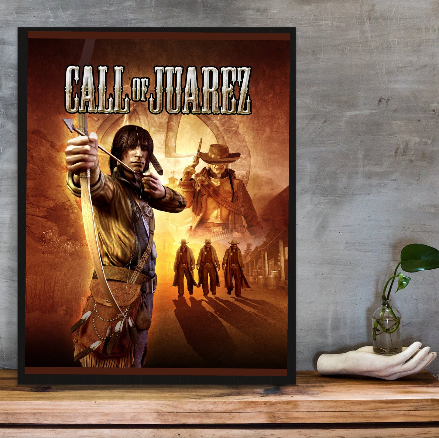 Call of Juarez key art with logo in a black frame on a wooden shelf against concrete