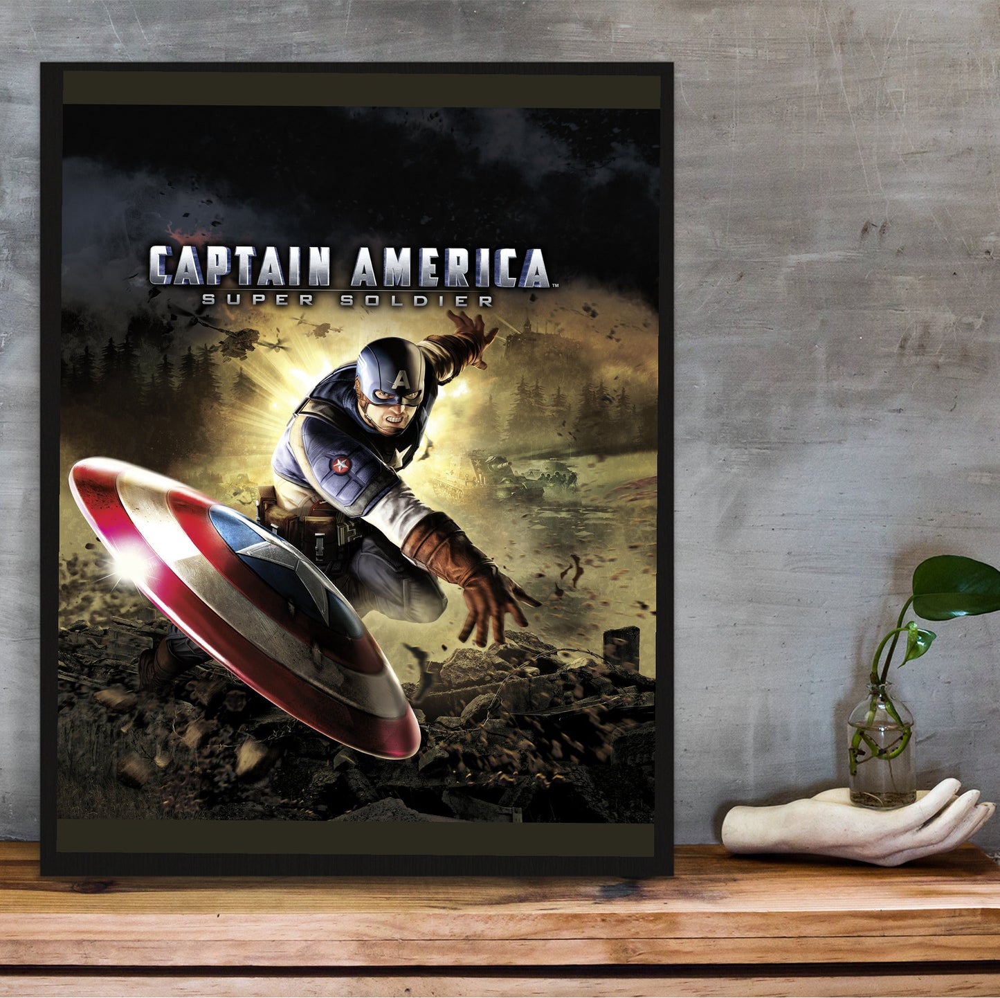 Captain America Super Soldier cover art with logo in a black frame on a wooden shelf against concrete