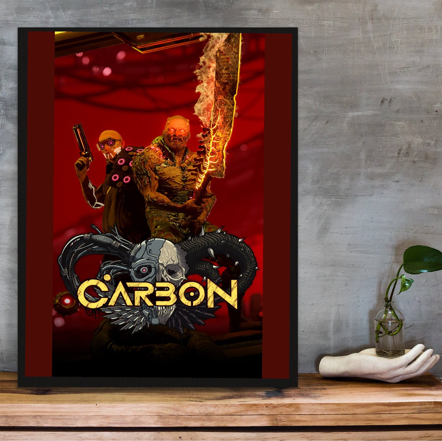 Carbon key art in a black frame on a wooden shelf against concrete