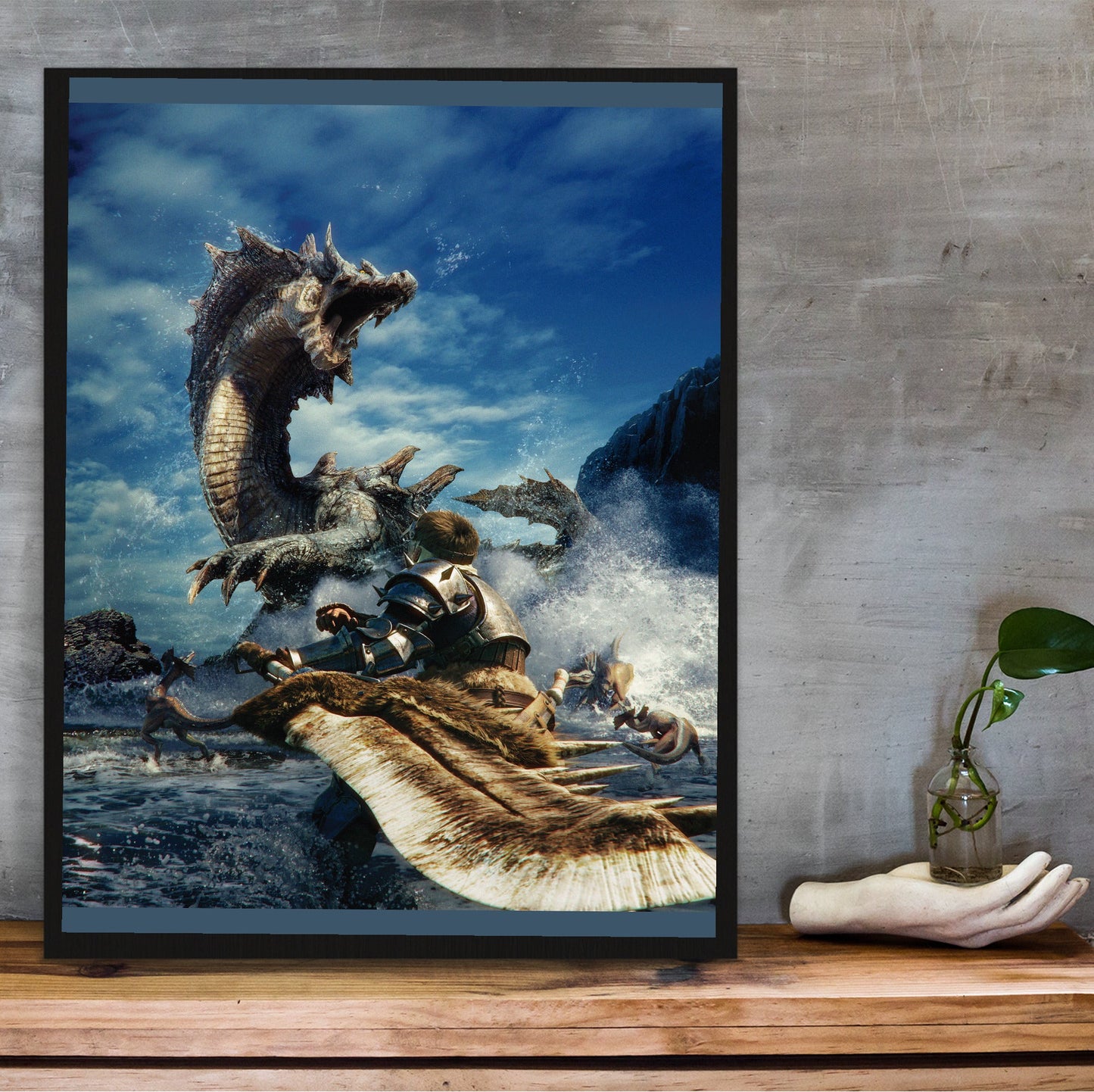 Monster Hunter Tri cover art in a black frame on a wooden shelf against concrete