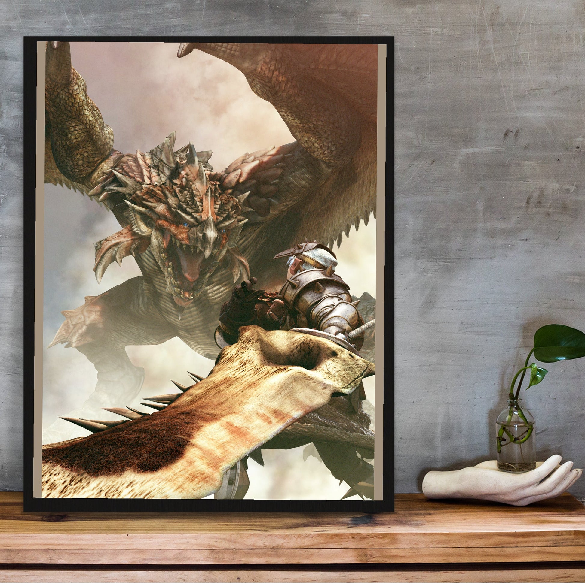 Monster Hunter Freedom cover art in a black frame on a wooden shelf against concrete