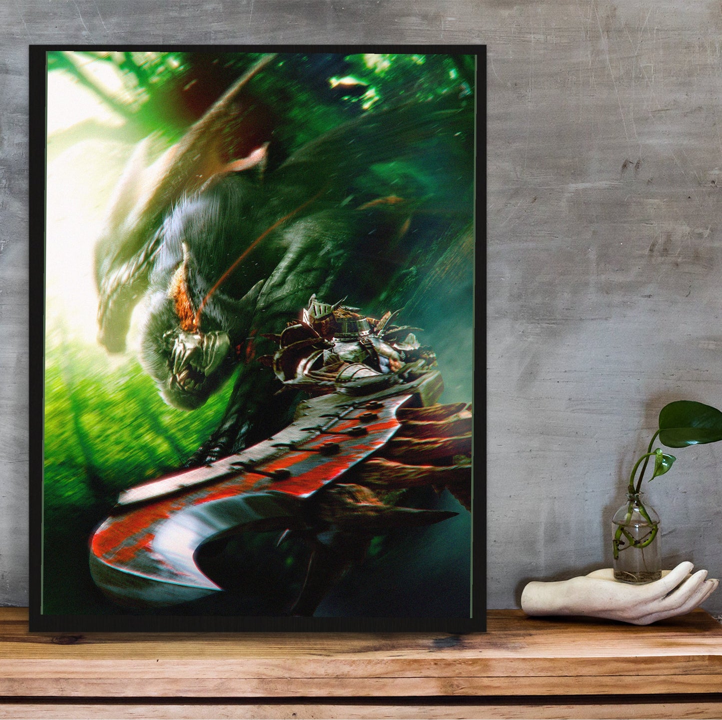 Monster Hunter Freedom Unite key art in a black frame on a wooden shelf against concrete