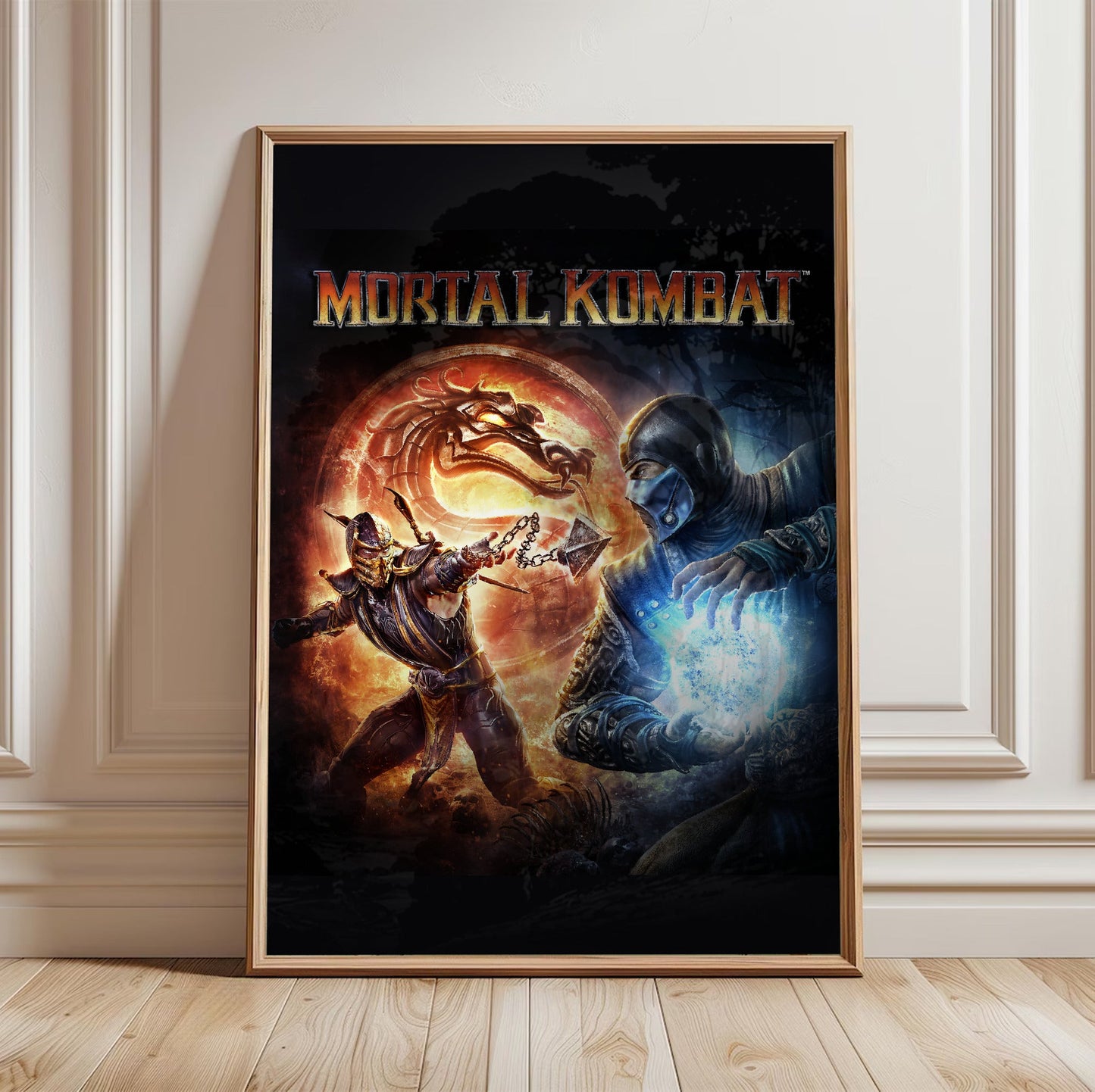 Mortal Kombat 9 cover art with logo in a light oak frame leaning against a white wall