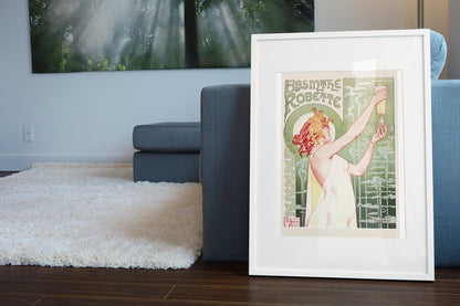 Absinthe Robette 1896 by Privat-Livemont poster in a white frame leaning beside a blue sofa