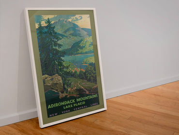 Adirondack Mountains NY Central poster in a white frame leaning against a wall