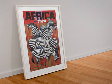 Africa Fly TWA poster in a white frame leaning against a wall