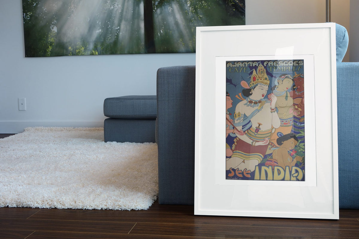 Ajanta Frescoes See India poster leaning beside a blue sofa