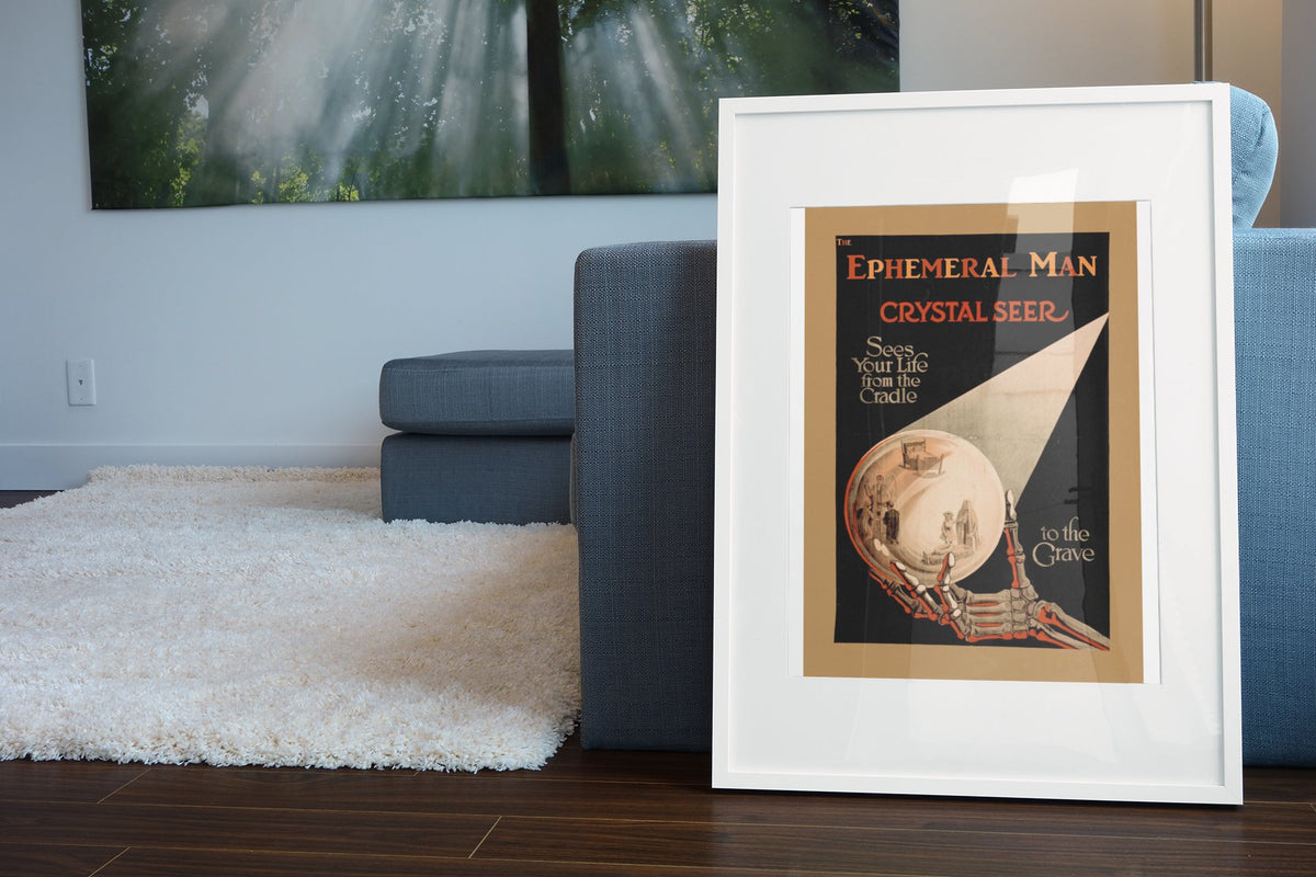 Alexander the Crystal Seer poster leaning beside a blue sofa