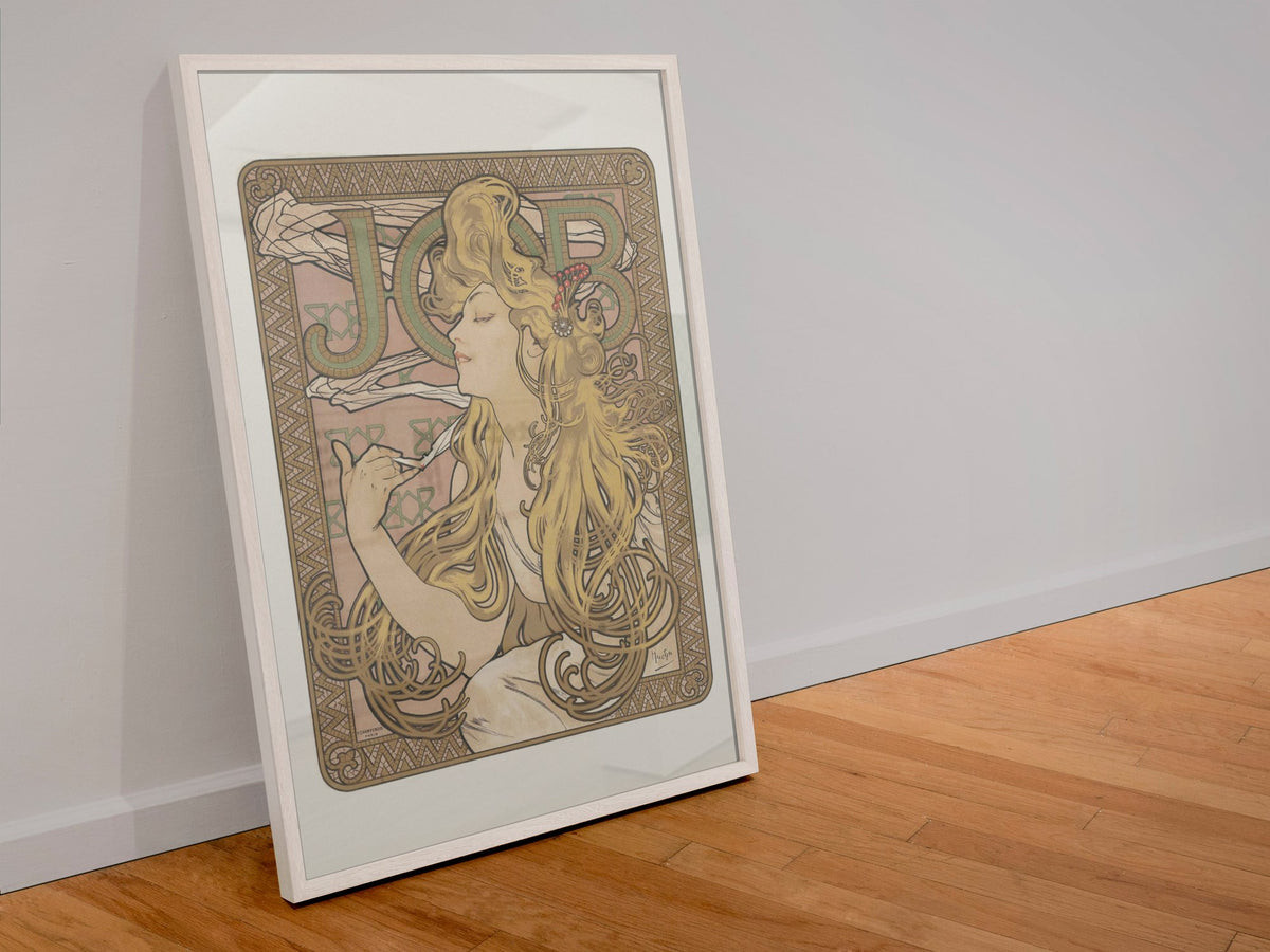 Alphonse Mucha JOB cigarette paper poster in a white frame leaning against a wall