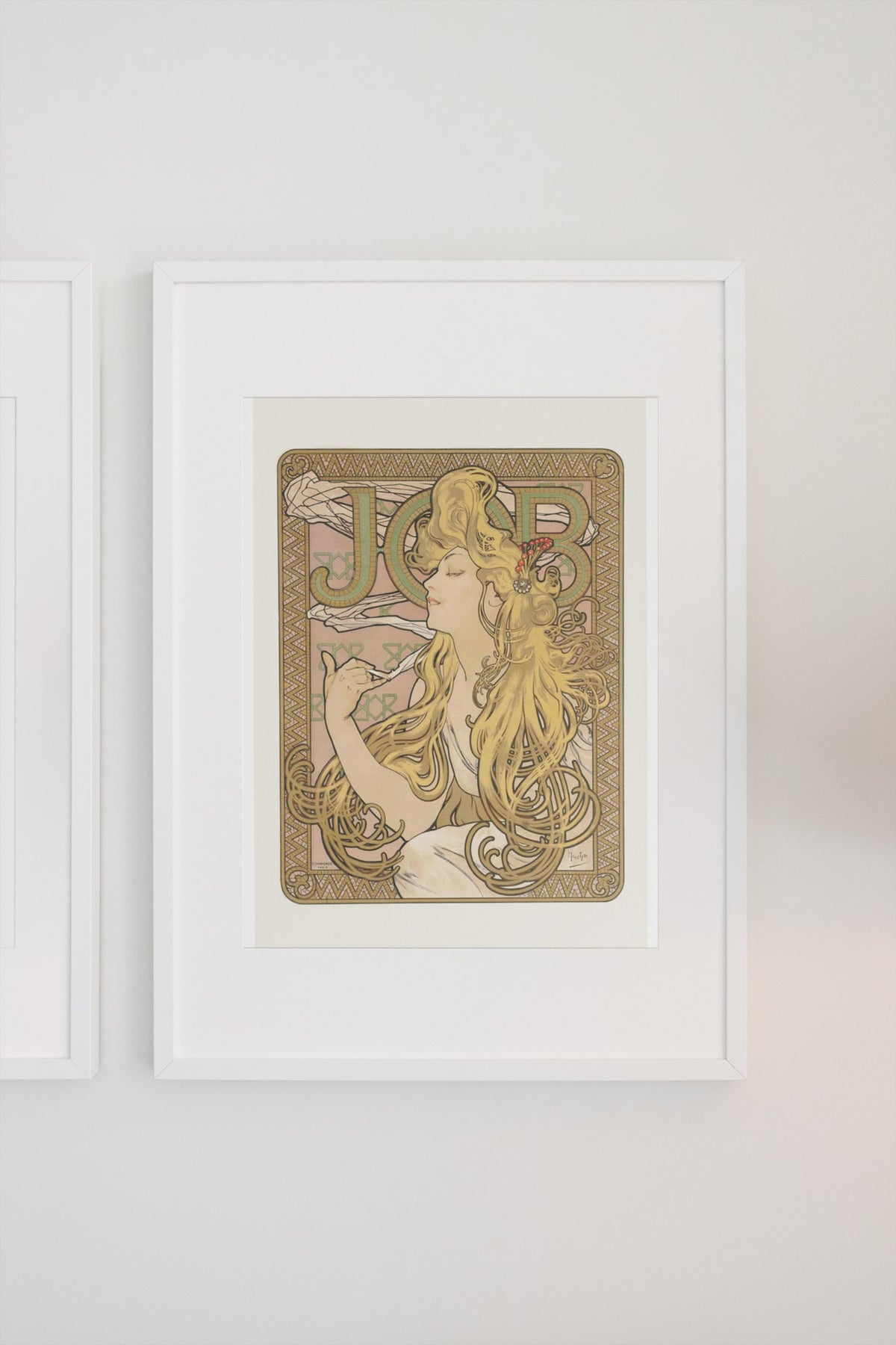 Alphonse Mucha JOB cigarette paper poster in a white frame on a light wall
