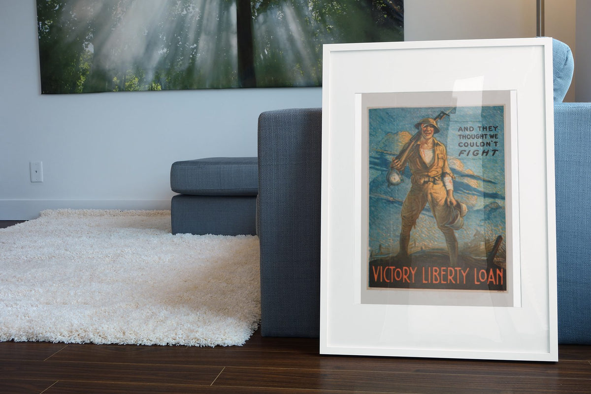 And They Thought We Couldnt Fight poster leaning beside a blue sofa