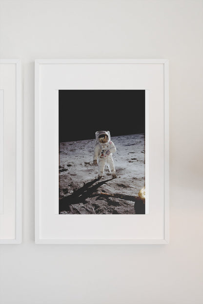 Apollo 11 Buzz Aldrin moonwalk poster in a white frame on a light wall