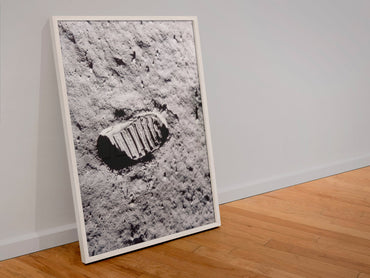 Apollo 11 bootprint on the Moon poster in a white frame leaning against a wall
